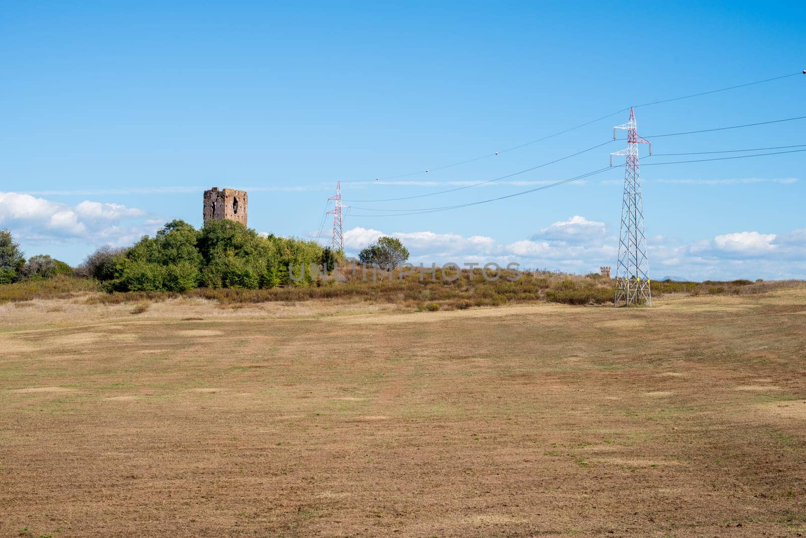 landscape of an ancient tower with power pylons