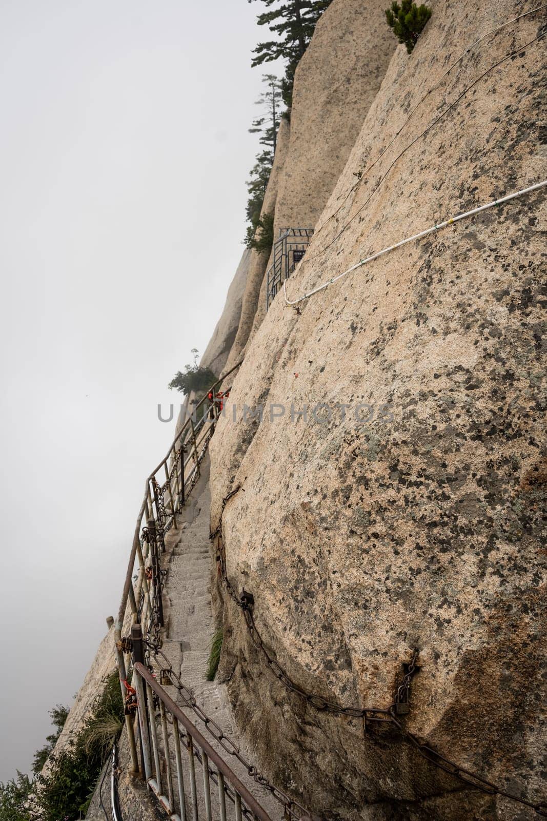Stone steps cut on a side of a mountain rock leading to the dangerous and perilous Plank Walk trail, closed for public access due to bad weather conditions, Huashan mountain, Xian, Shaanxi Province, China
