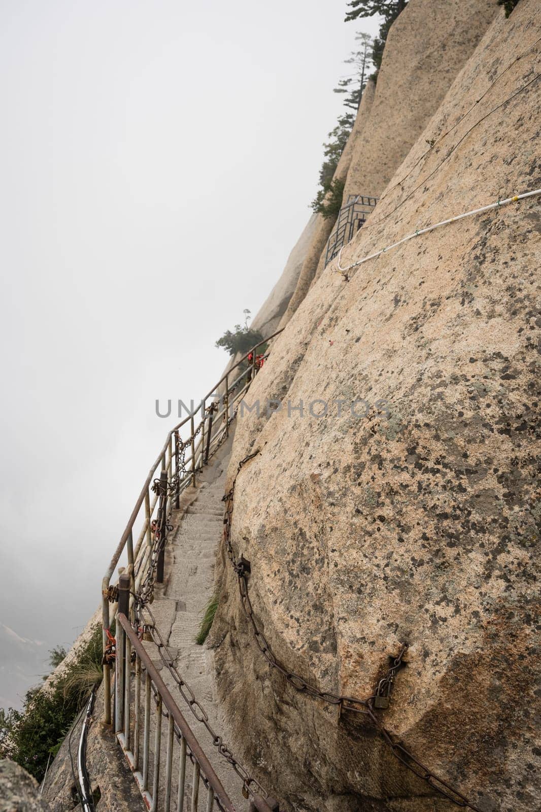 Stone steps cut on a side of a mountain rock leading to the dangerous and perilous Plank Walk trail, closed for public access due to bad weather conditions, Huashan mountain, Xian, Shaanxi Province, China