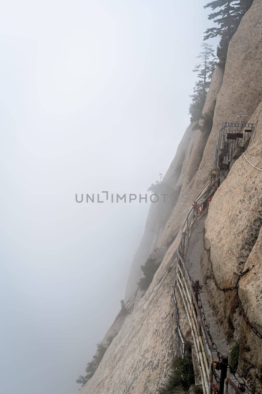 Stone steps cut on a side of a mountain rock leading to the dangerous and perilous Plank Walk trail, closed for public access due to bad weather conditions, Huashan mountain, Xian, Shaanxi Province, China