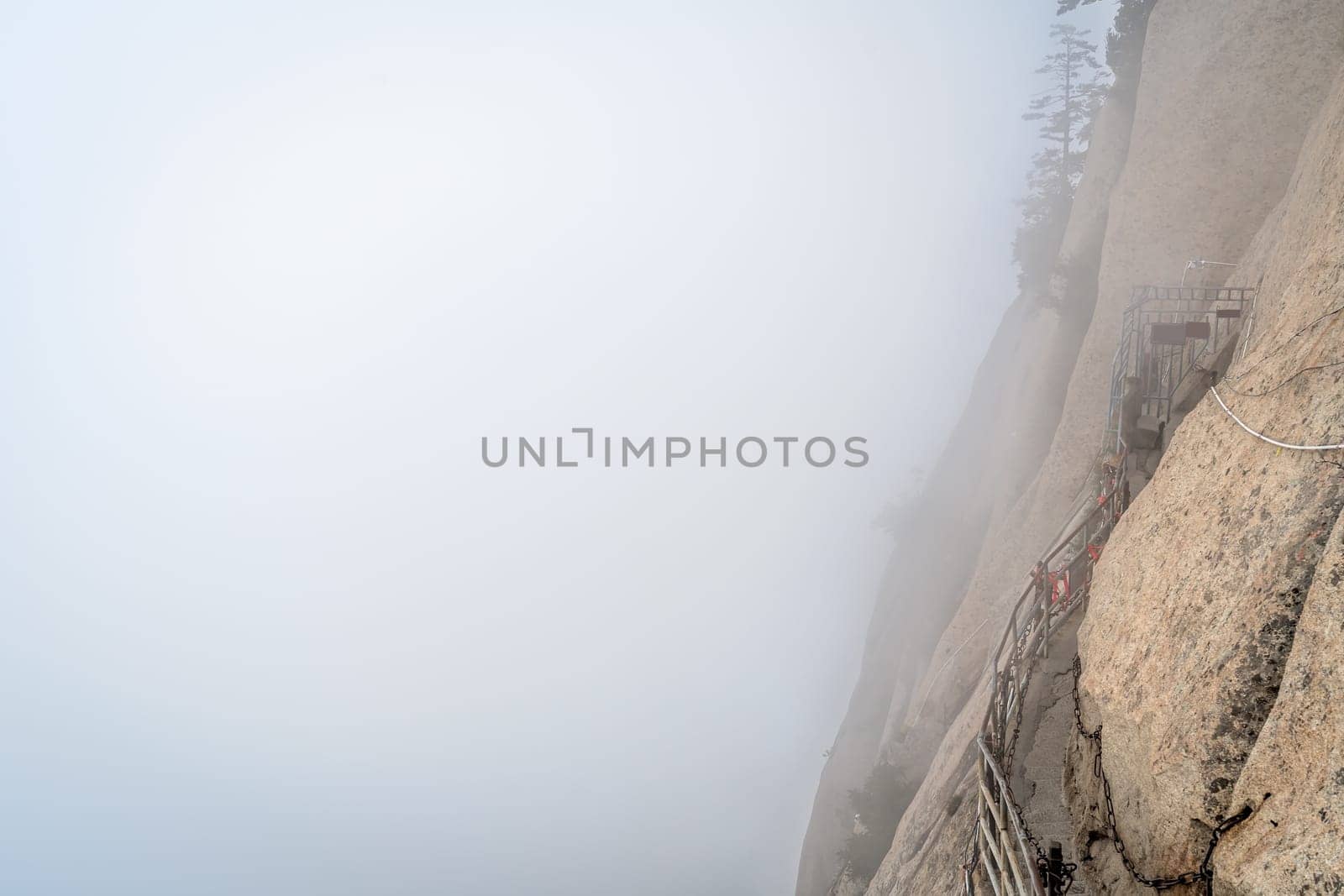 Stone steps cut on a side of a mountain rock leading to the dangerous and perilous Plank Walk trail, closed for public access due to bad weather conditions, Huashan mountain, Xian, Shaanxi Province, China