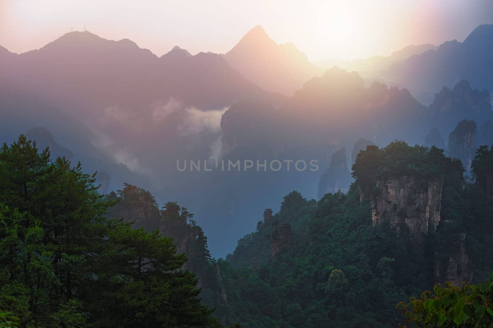 Sun shining over the stone pillars of Tianzi mountains in Zhangjiajie National park which is a famous tourist attraction, Wulingyuan, Hunan Province, China