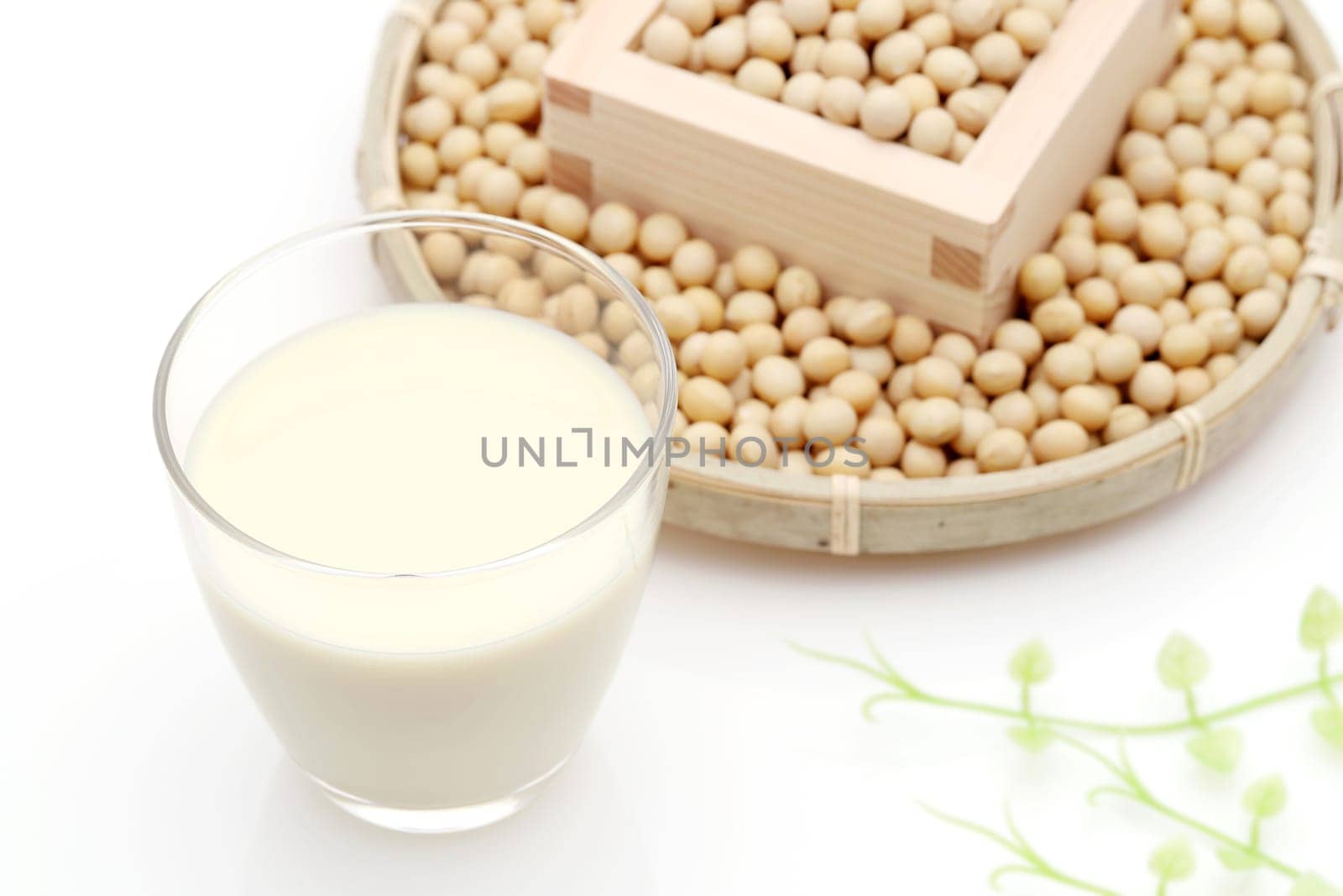 Glass of soy milk with soy bean on white background