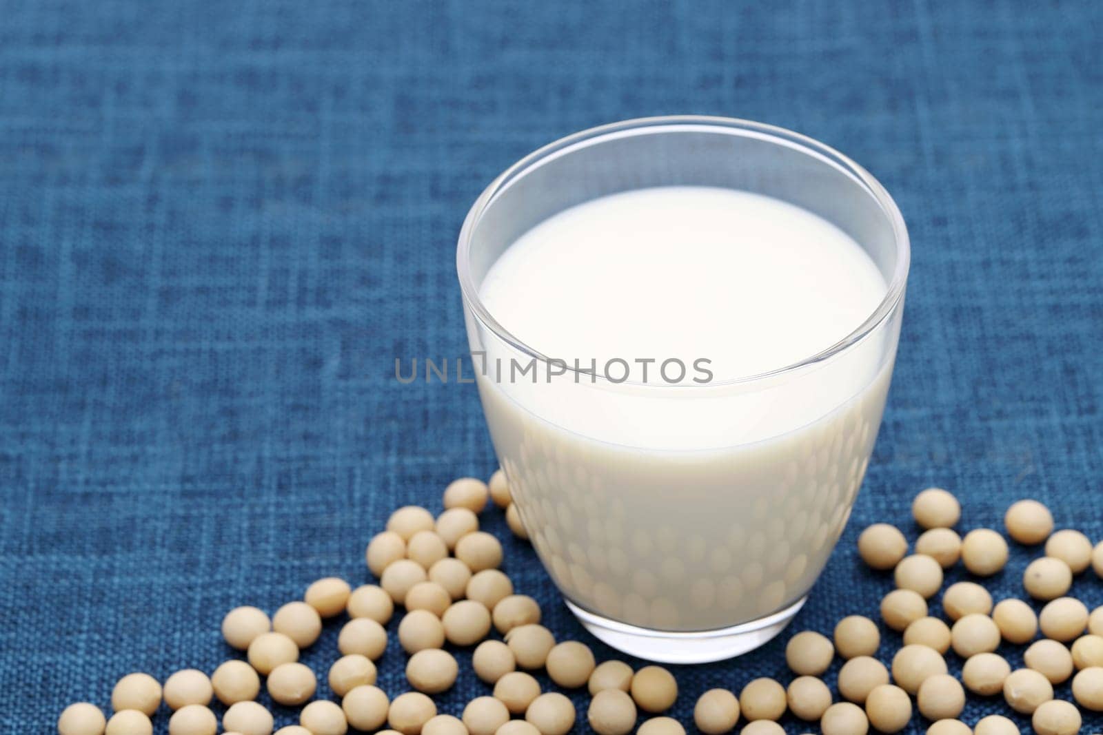 Glass of soy milk with soy bean on dining table