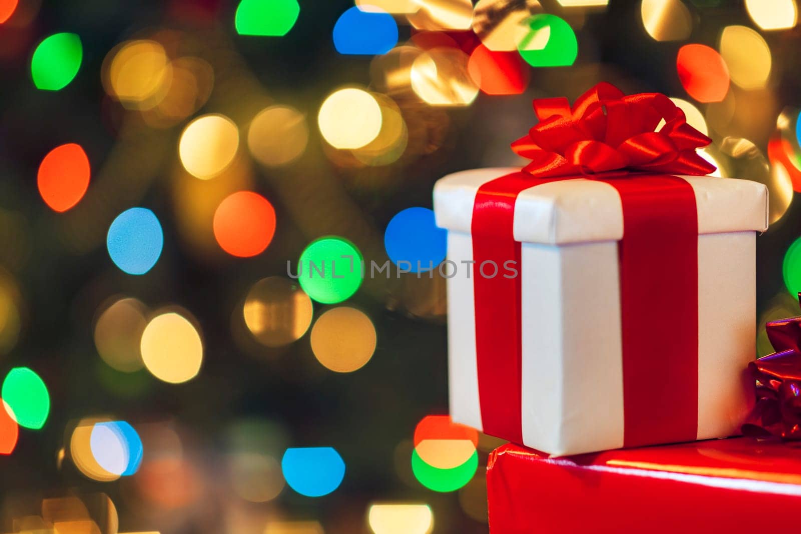 gift boxes with ribbon and bow on holiday lights background