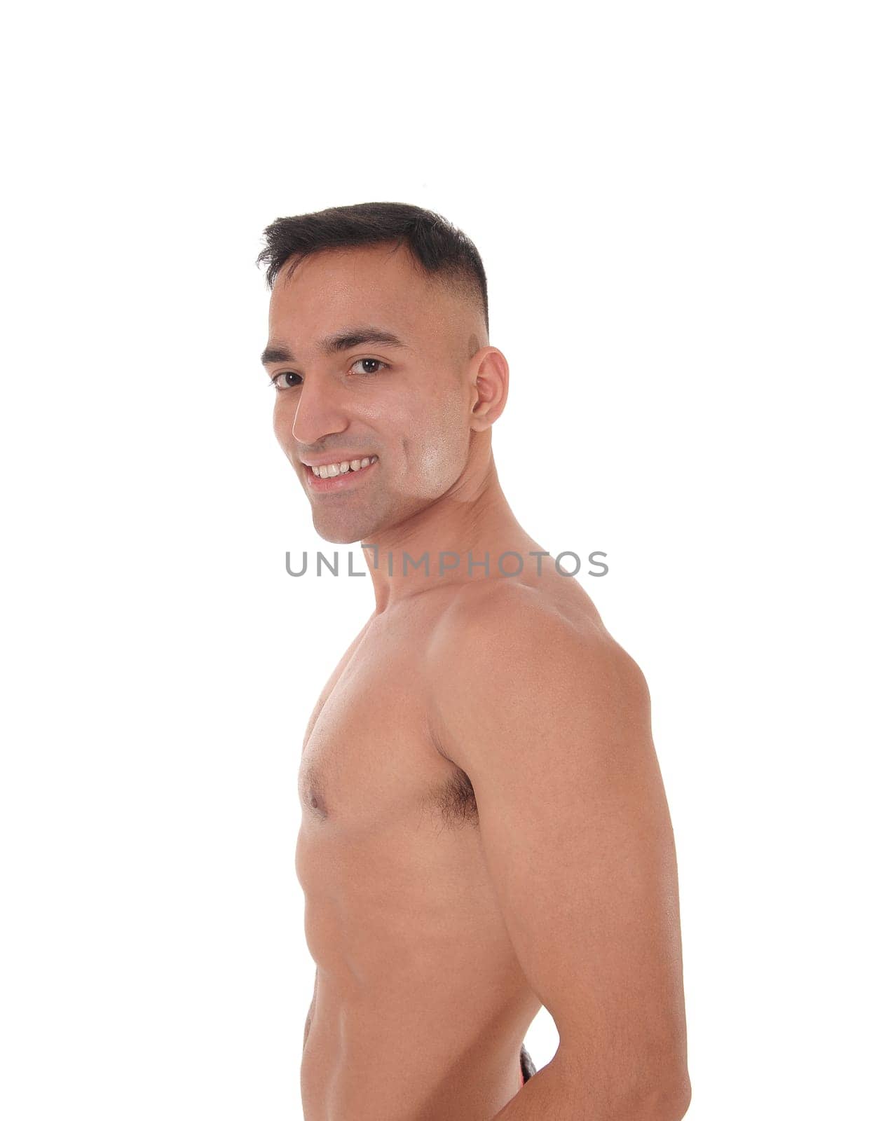 A handsome young east Indian man standing shirtless and smiling.looking into the camera, isolated for white background.