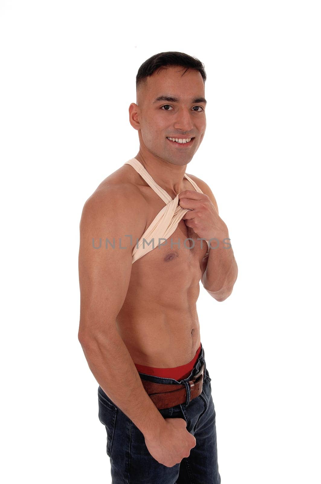 A handsome young east Indian man standing shirtless and smiling.in jeans with red underwear, isolated for white background.