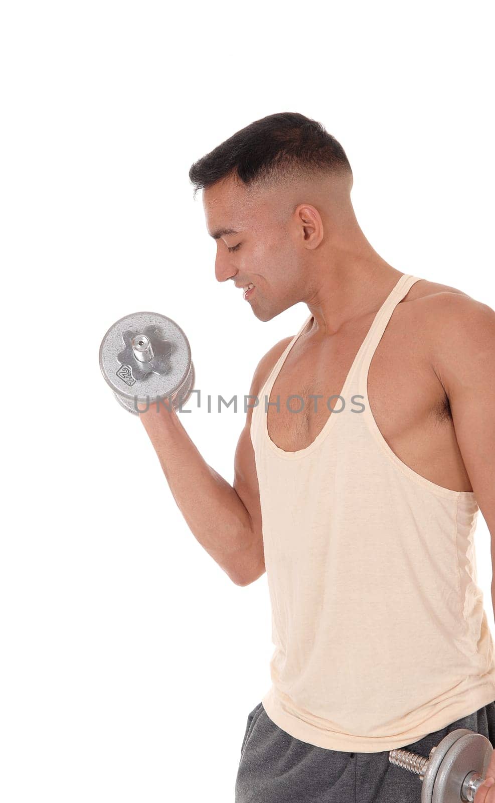 A handsome young man working out with two dumbbell with his.eyes closed, wearing his truck pants, isolated for white background.