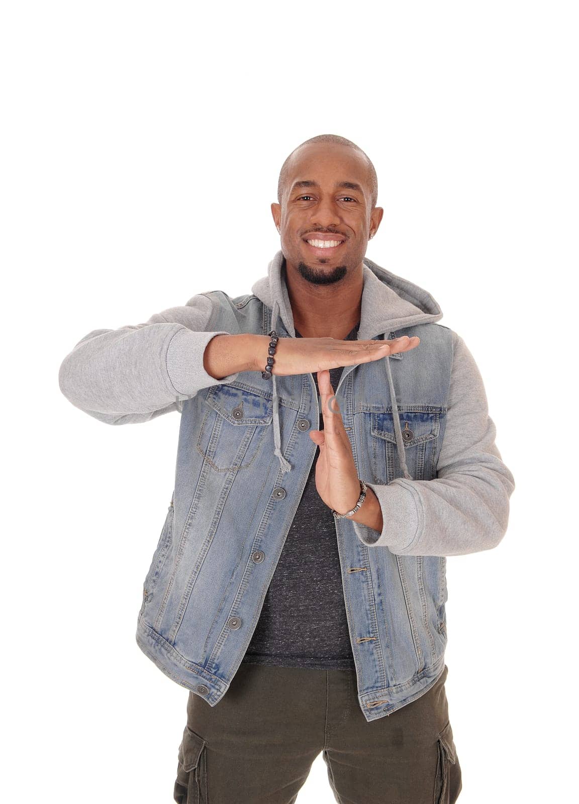A handsome young African American man standing halve length in a .jeans jacket and signing to talk, isolated for white background.