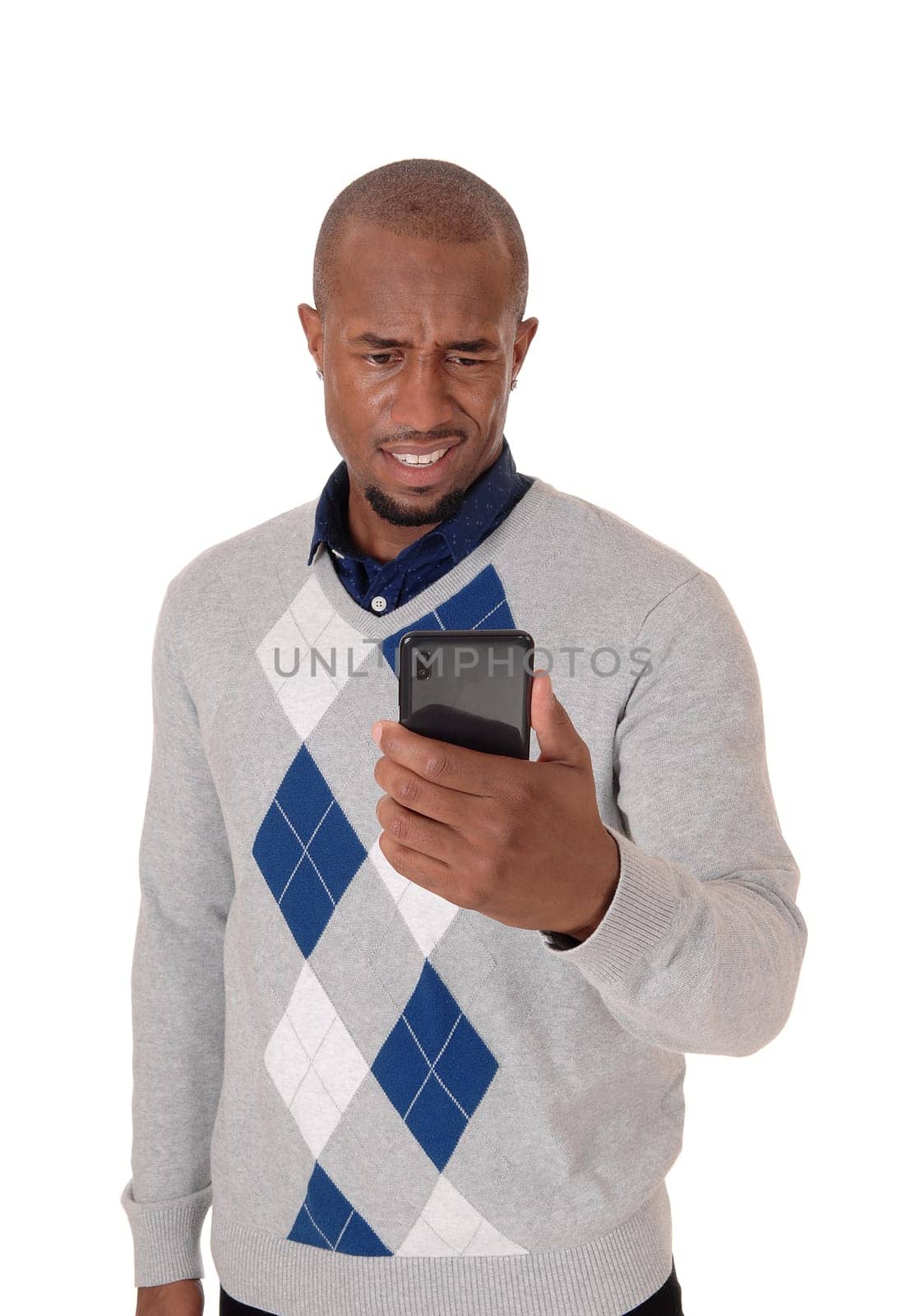 A young angry African American man standing in a sweater with his phone.in his hand confused what hi sees, isolated for white background.