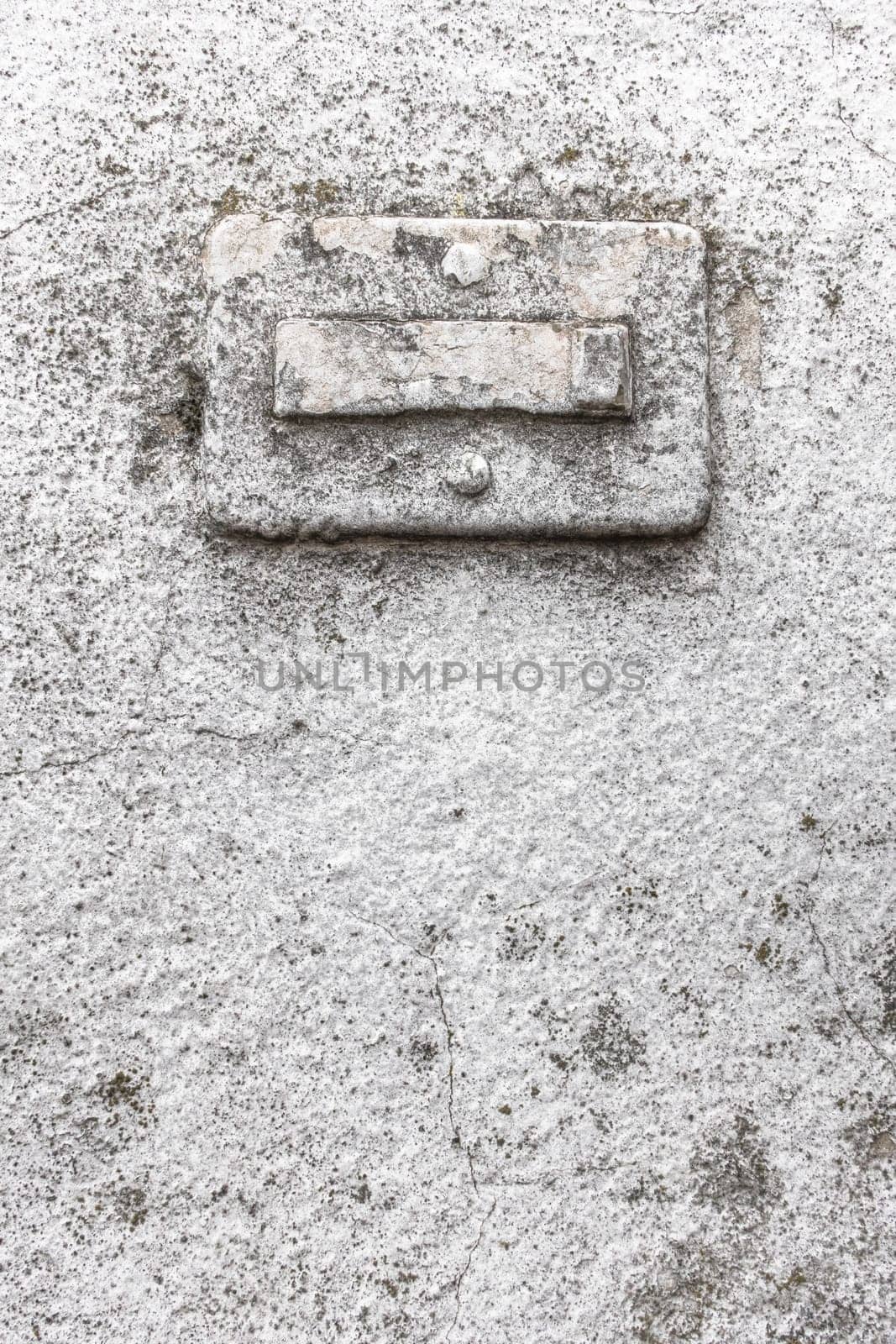 Broken doorbell, covered in paint, on a grungy wall with cracks and molds. Ideal for creative backgrounds.