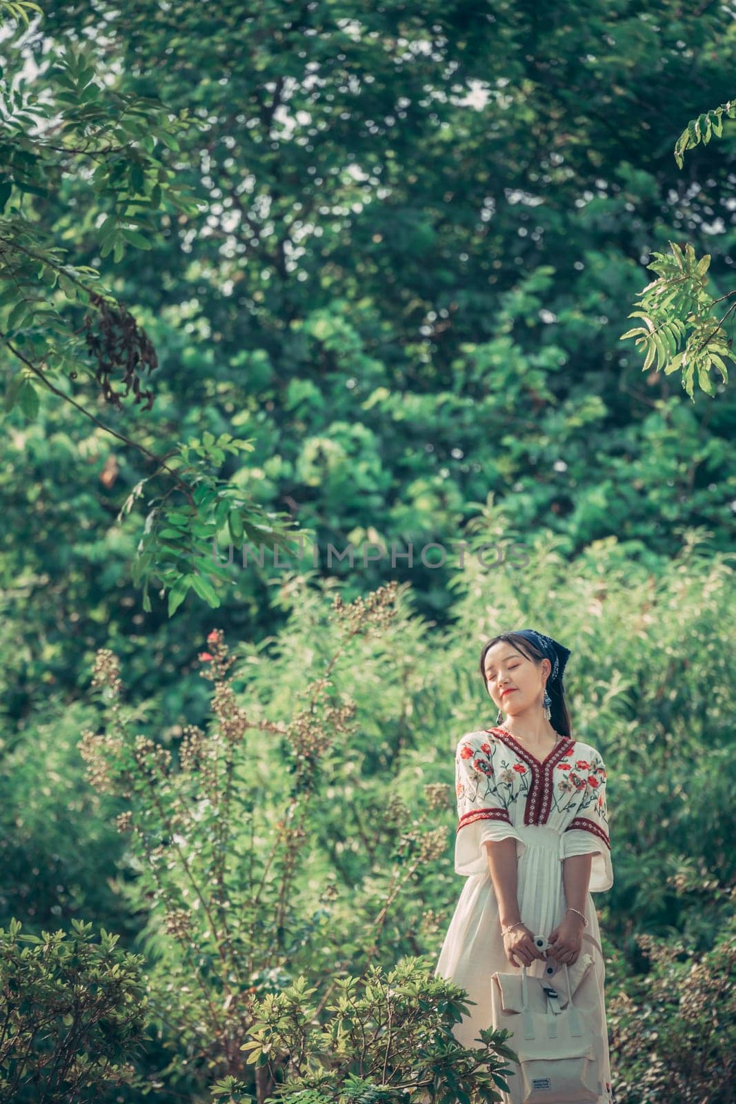 Guilin, China -  August 2019 : Chinese woman dressed in a traditional costume posing for a photograph in a public park in Guilin in summer