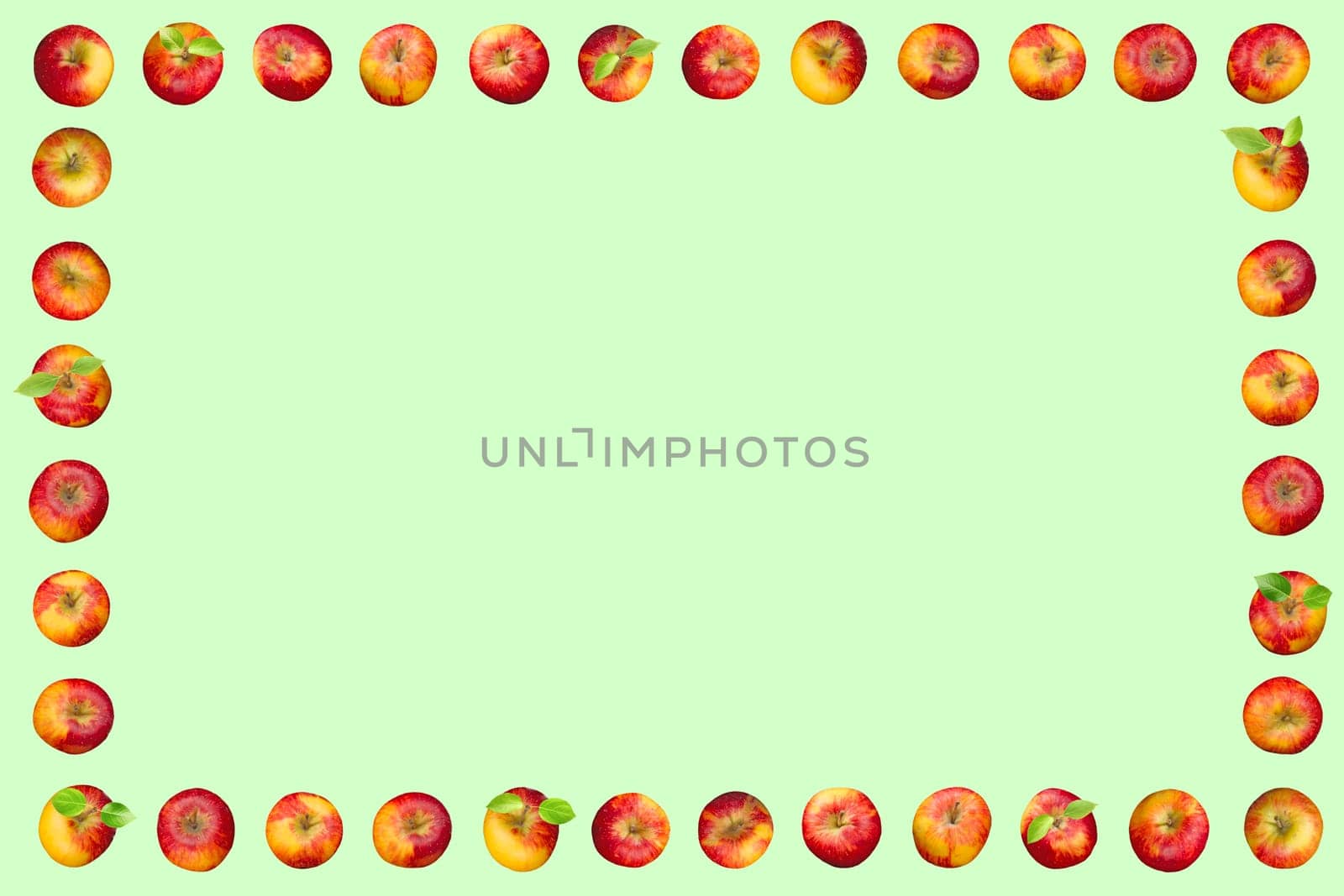 Frame of apples isolated on a green background. With apple leaves.