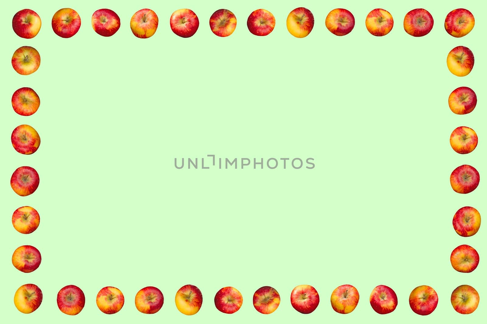 Frame of apples isolated on a green background.