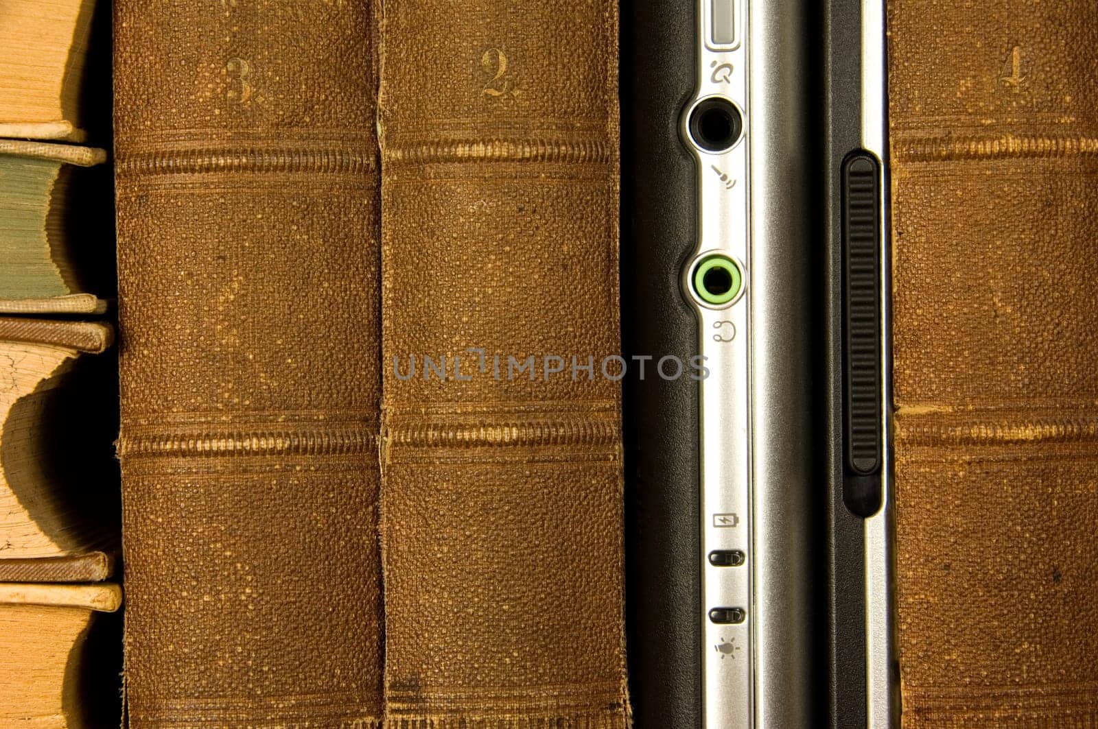 Laptop standing between antiquated books like in a library