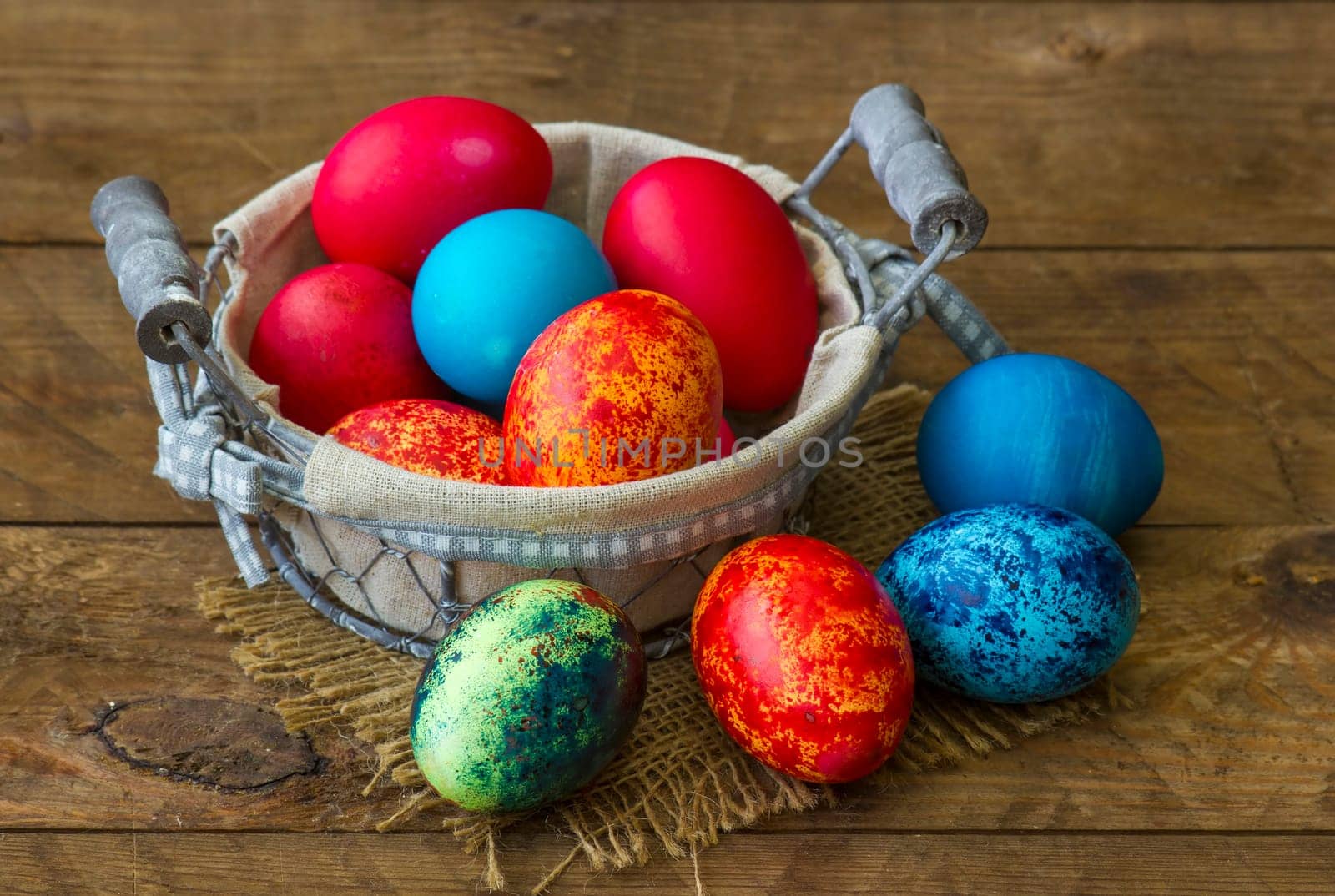 Happy Easter, colorful eggs in a basket on wooden background
