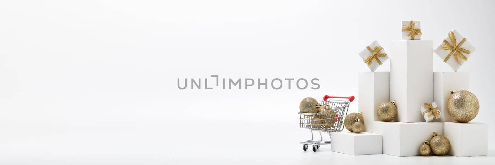 Shopping trolley, gift boxes and Christmas decorations isolated on white background with copy space. Christmas and New Year shopping. Winter sale. For design of advertising, web design