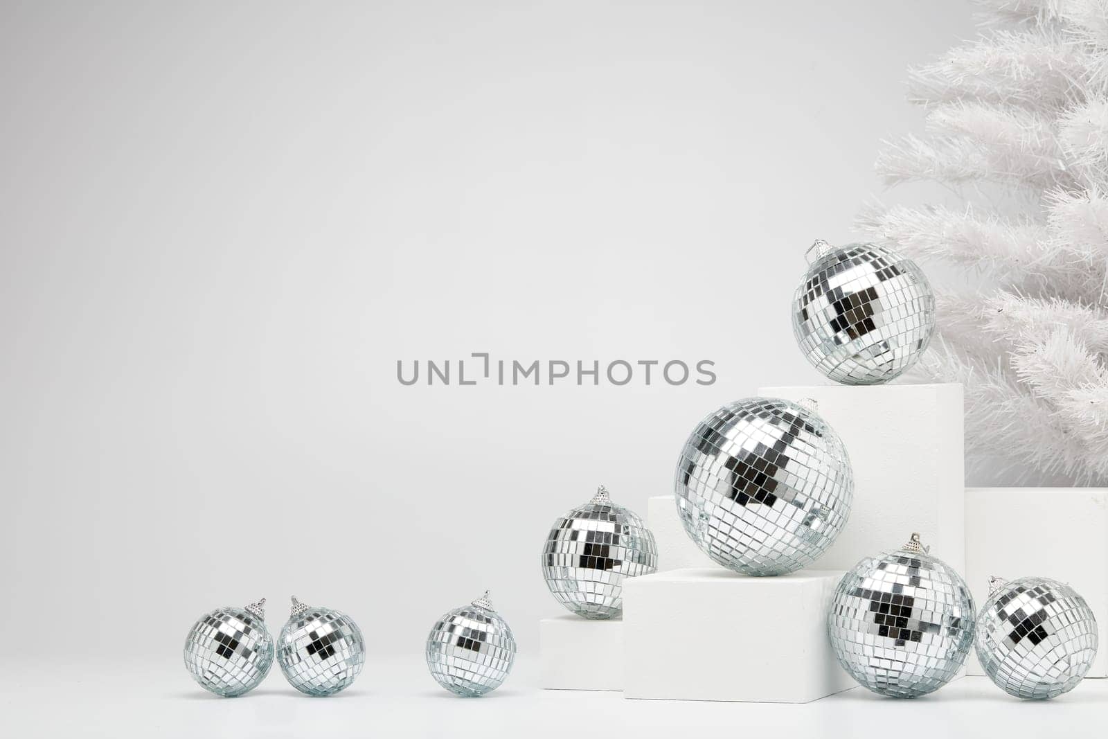 Festive composition with white geometrical figures, Christmas fir tree and mirorr balls isolated on white background with copy space. For design of advertising, web design. Christmas and New Year