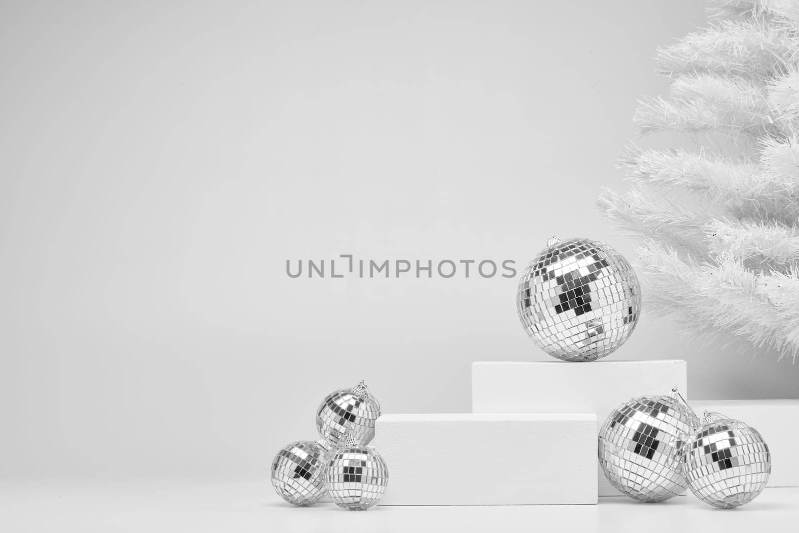 Festive composition with white geometrical figures, Christmas fir tree and mirorr balls isolated on white background with copy space. For design of advertising, web design. Christmas and New Year