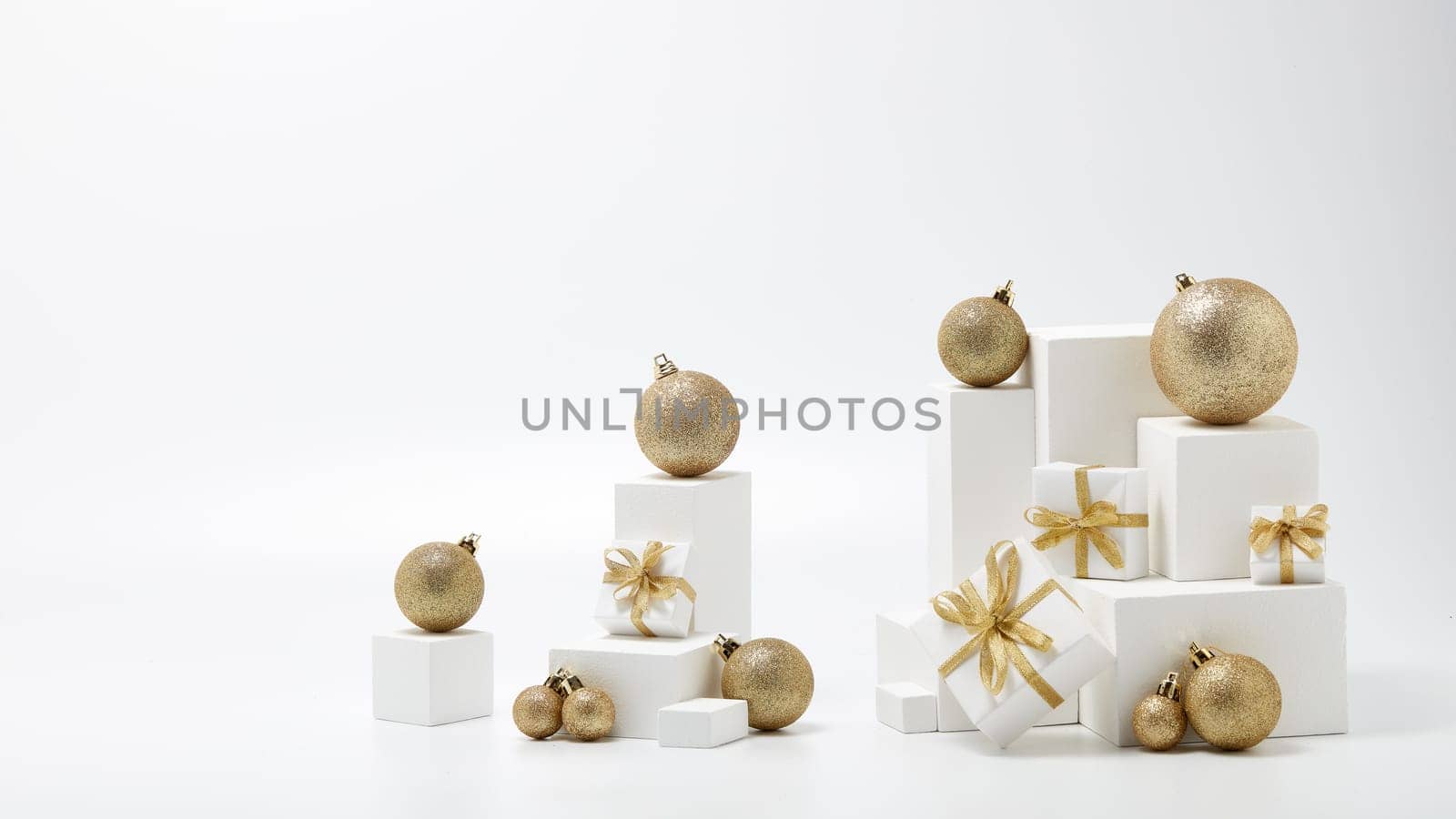 Festive composition with white geometrical figures, Christmas decorations and gift boxes isolated on white background with copy space. For design of advertising, web design. Christmas and New Year
