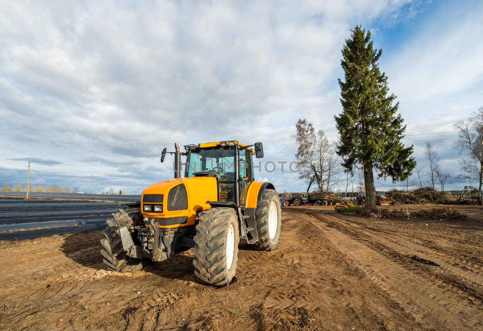Yellow tractor stay at the field after works