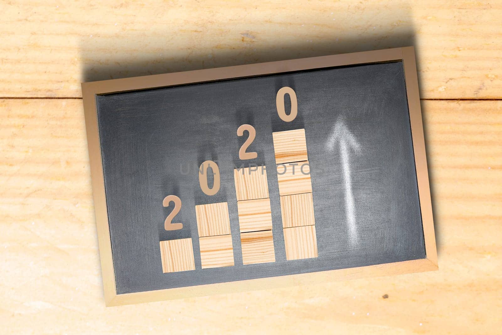 2020 on stairs of the wooden cube inside the blackboard. Happy New Year 2020