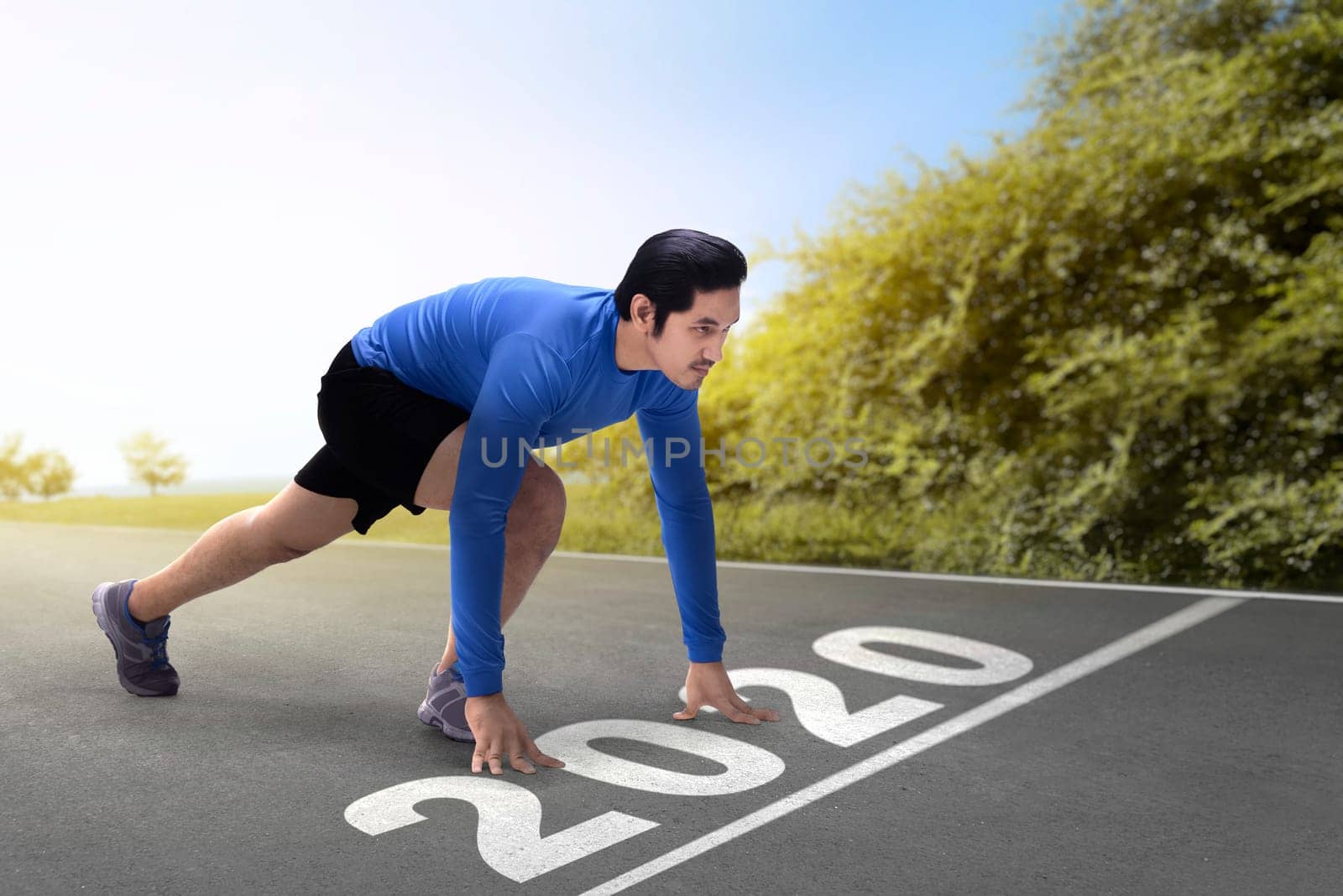 Asian runner man ready to run on the 2020 line. Happy New Year 2020