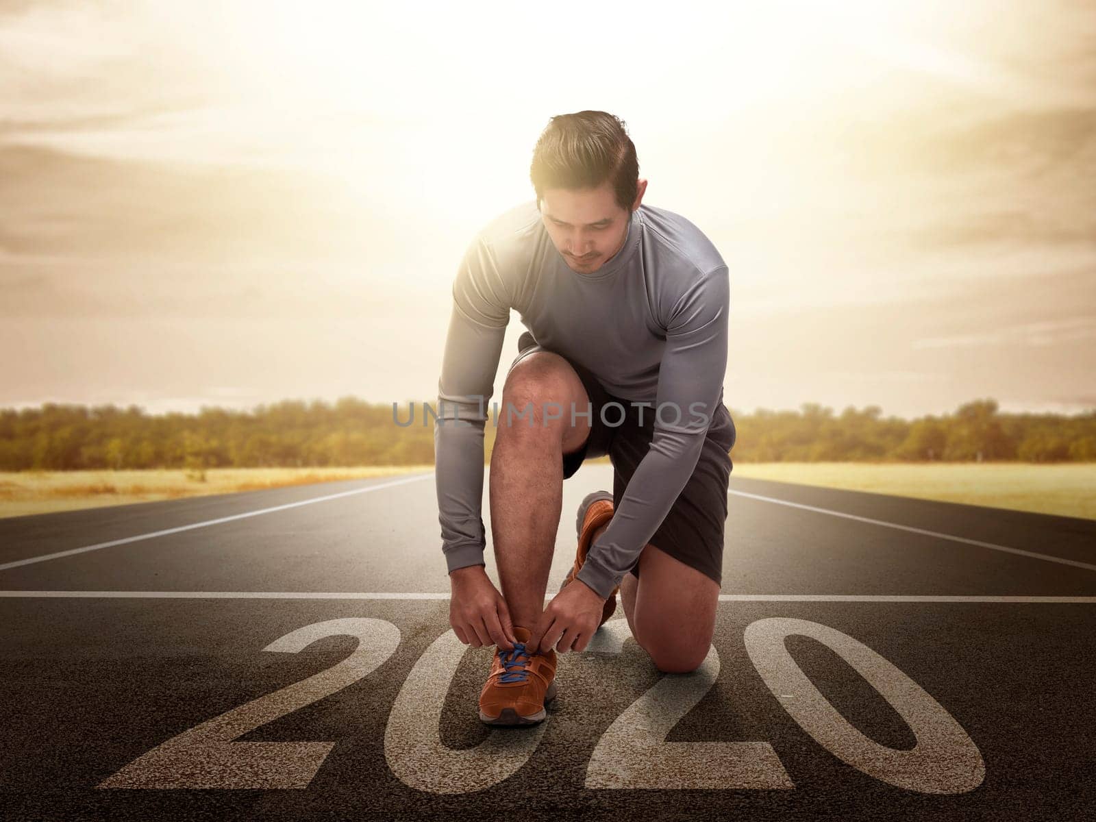 Asian runner man prepares to run on the 2020 line. Happy New Year 2020