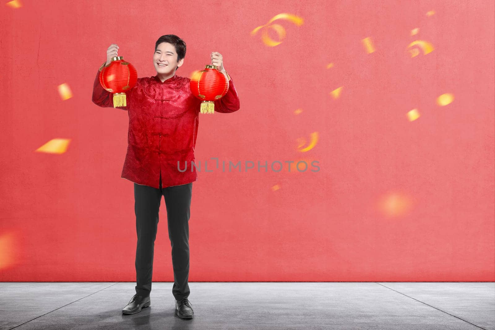An Asian Chinese man in a cheongsam dress holding Chinese lantern. Happy Chinese New Year