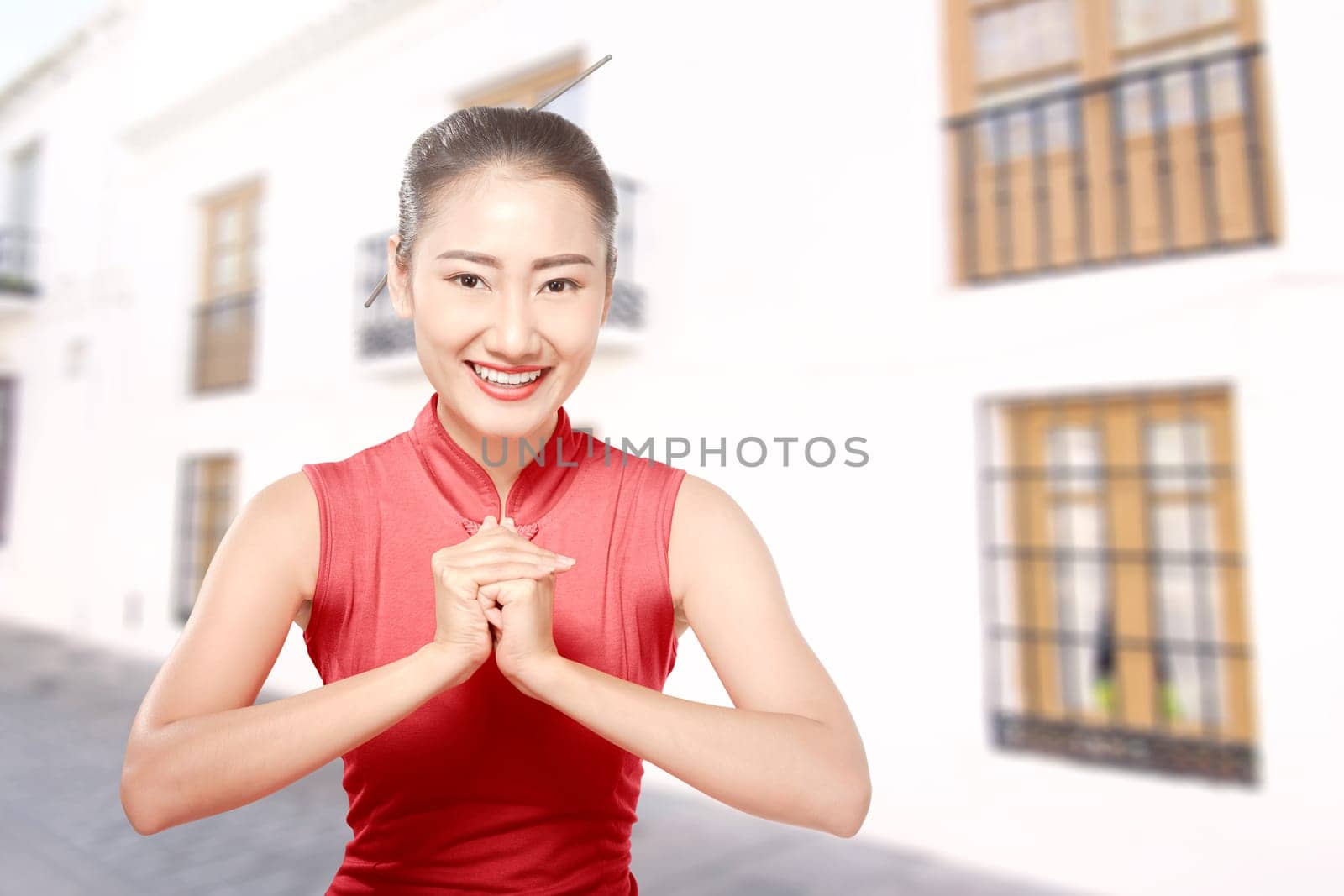 Asian Chinese woman in a cheongsam dress with congratulations gesture. Happy Chinese New Year