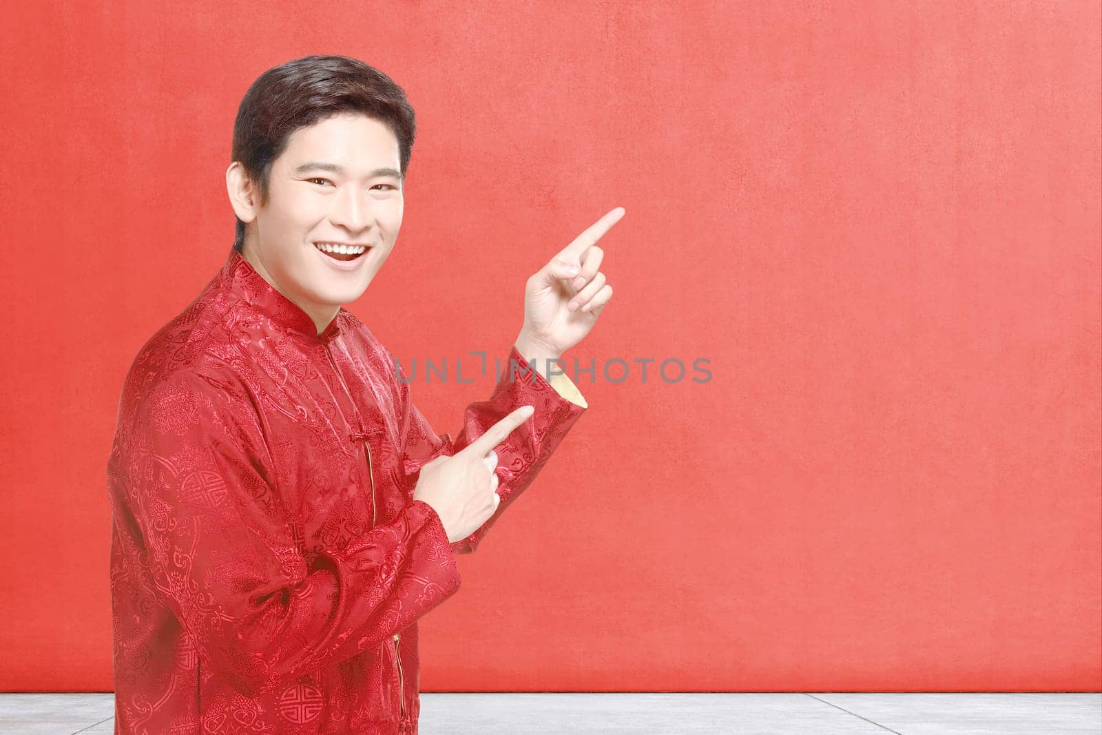 An Asian Chinese man in cheongsam dress celebrates Chinese New Year. Happy Chinese New Year