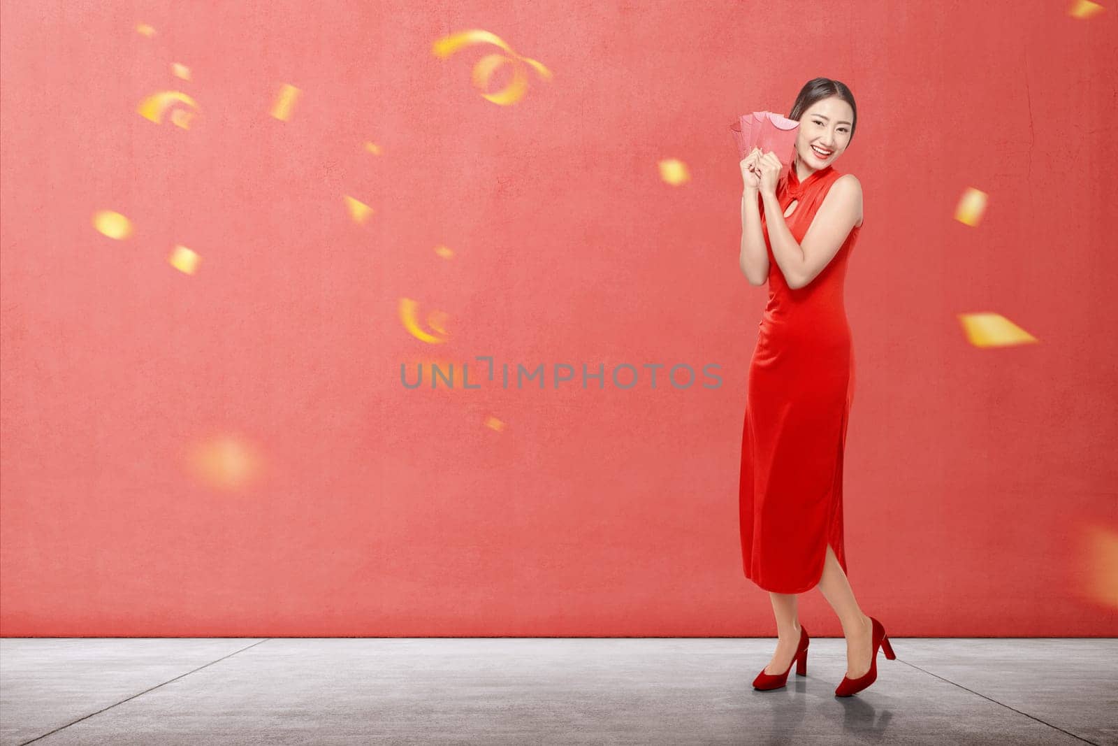 Asian Chinese woman in a cheongsam dress holding red envelopes. Happy Chinese New Year