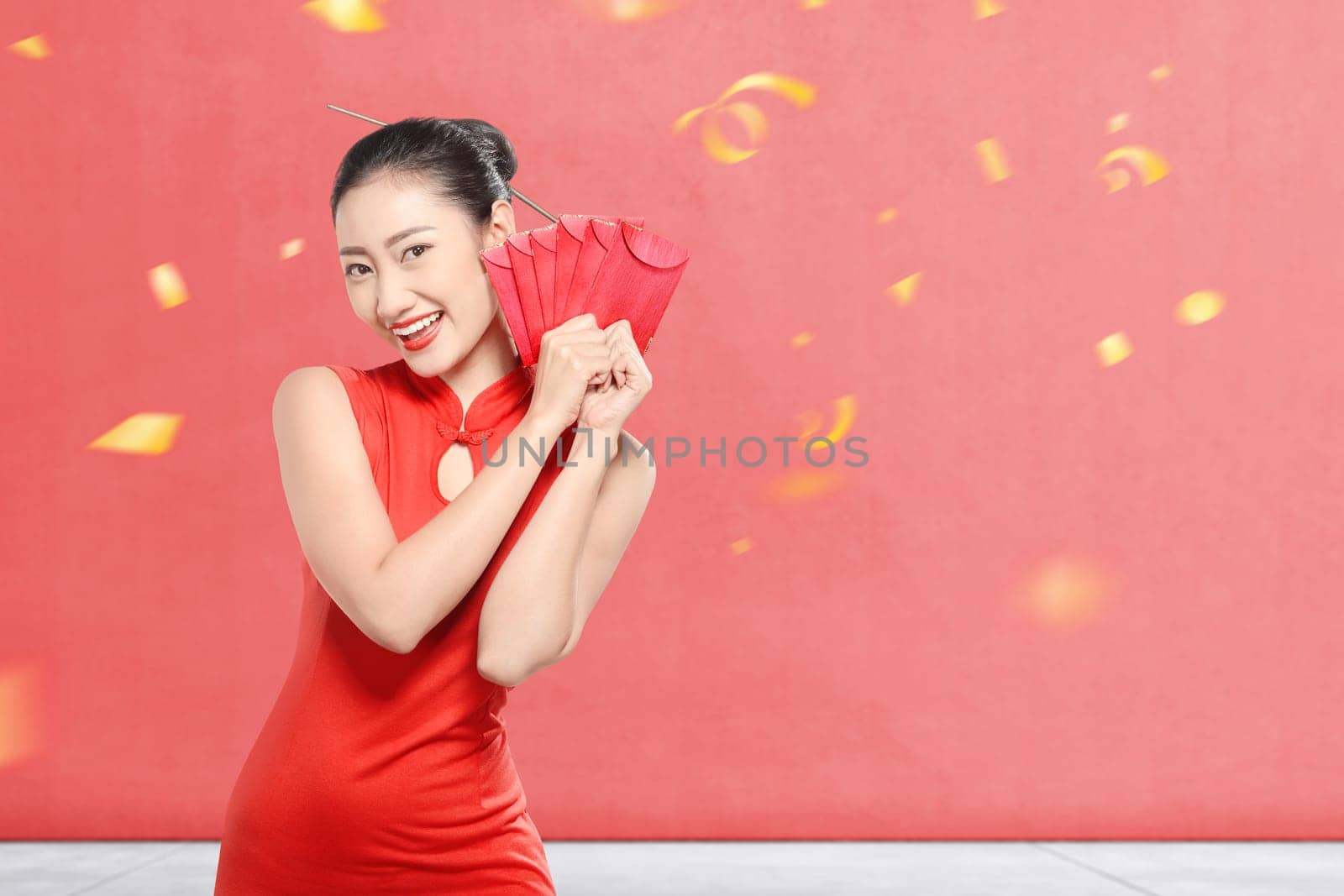 Asian Chinese woman in a cheongsam dress holding red envelopes. Happy Chinese New Year