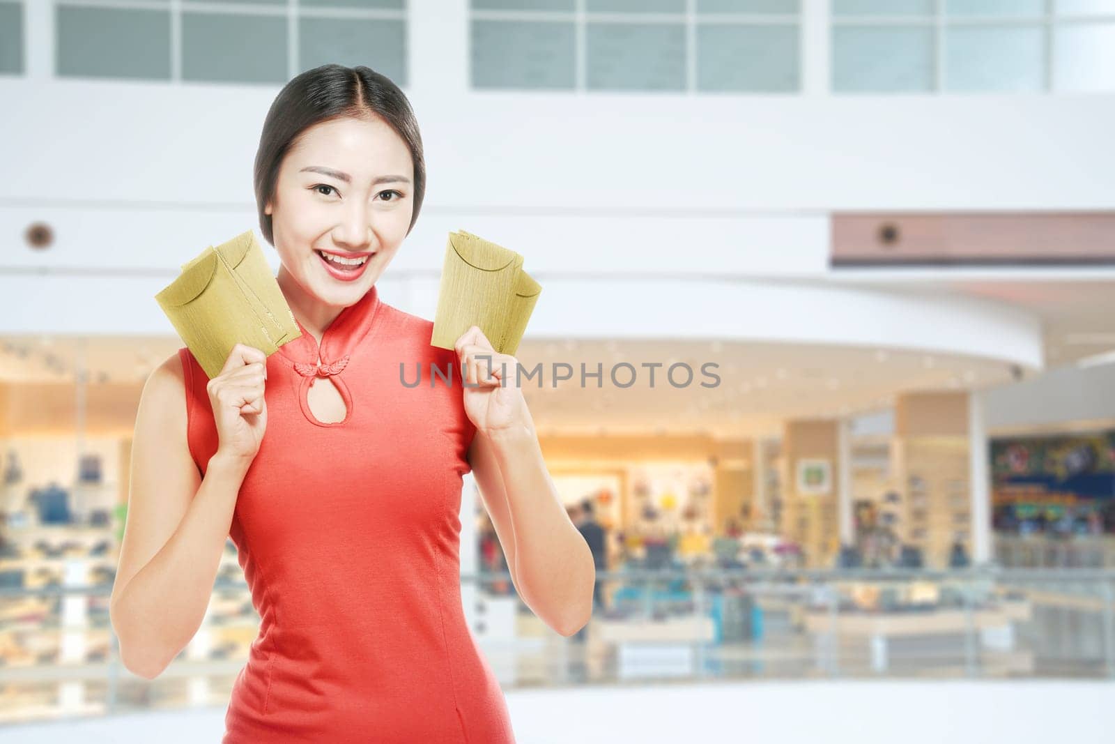 Asian Chinese woman in a cheongsam dress holding red envelopes. Happy Chinese New Year