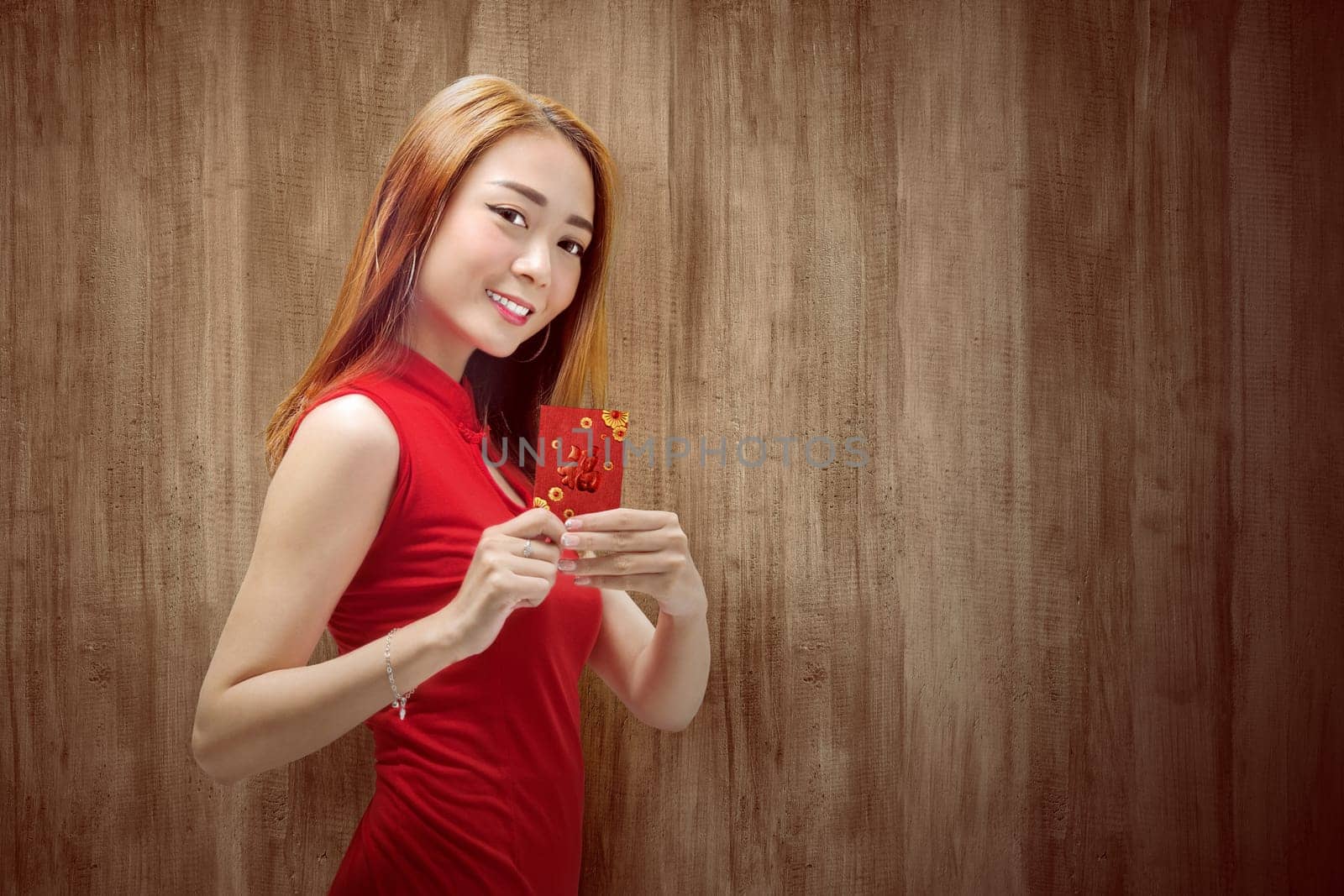Asian Chinese woman in a cheongsam dress holding red envelopes. Happy Chinese New Year