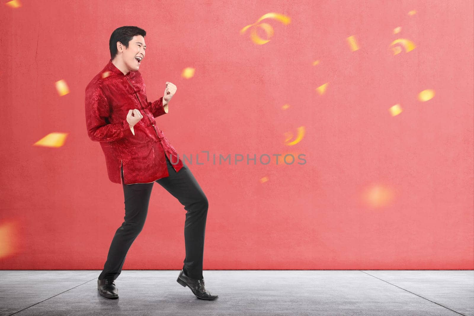 An Asian Chinese man in cheongsam dress celebrates Chinese New Year. Happy Chinese New Year