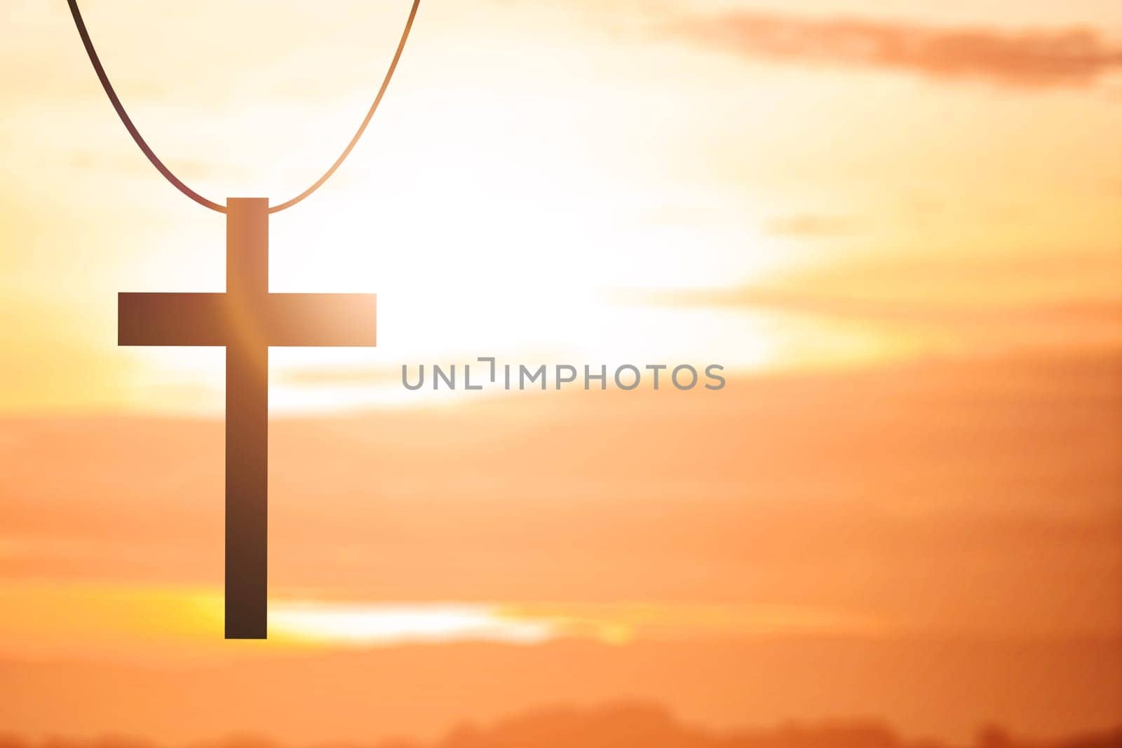 Image of Christian cross with a sunset sky background
