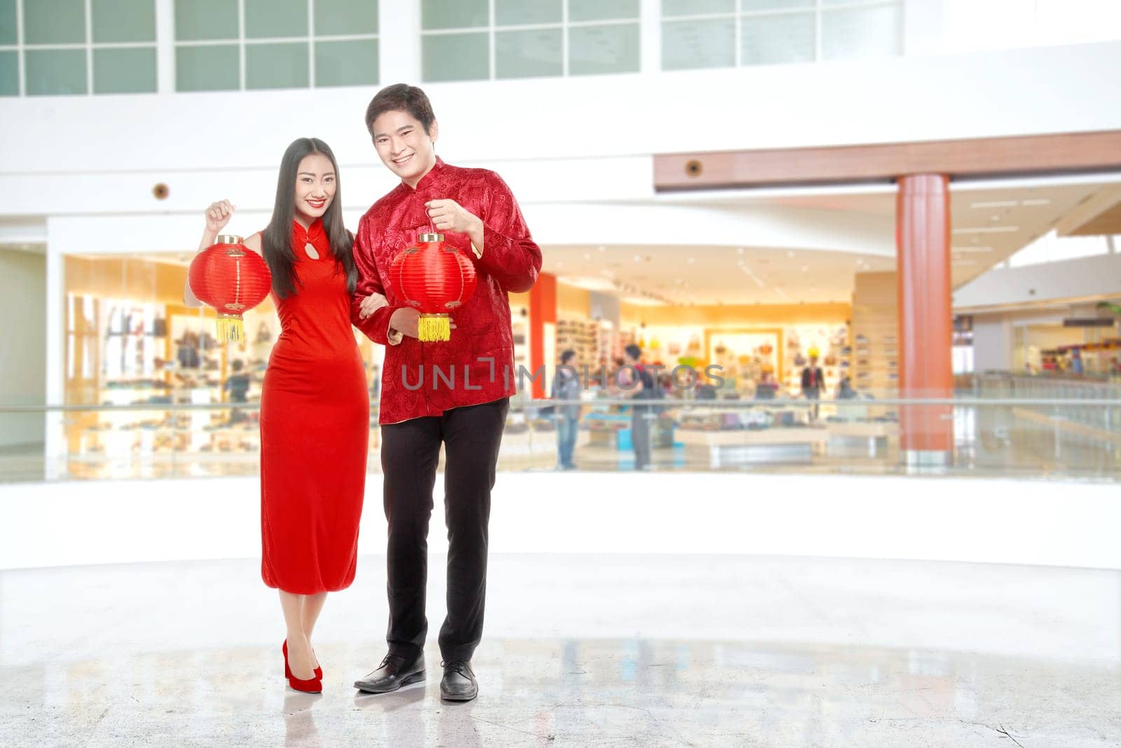 Asian Chinese couple in cheongsam dress holding Chinese lantern. Happy Chinese New Year