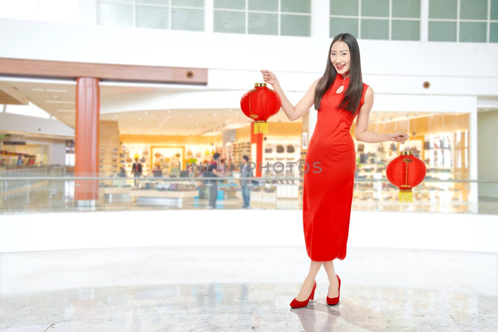 Asian Chinese woman in a cheongsam dress holding Chinese lantern. Happy Chinese New Year