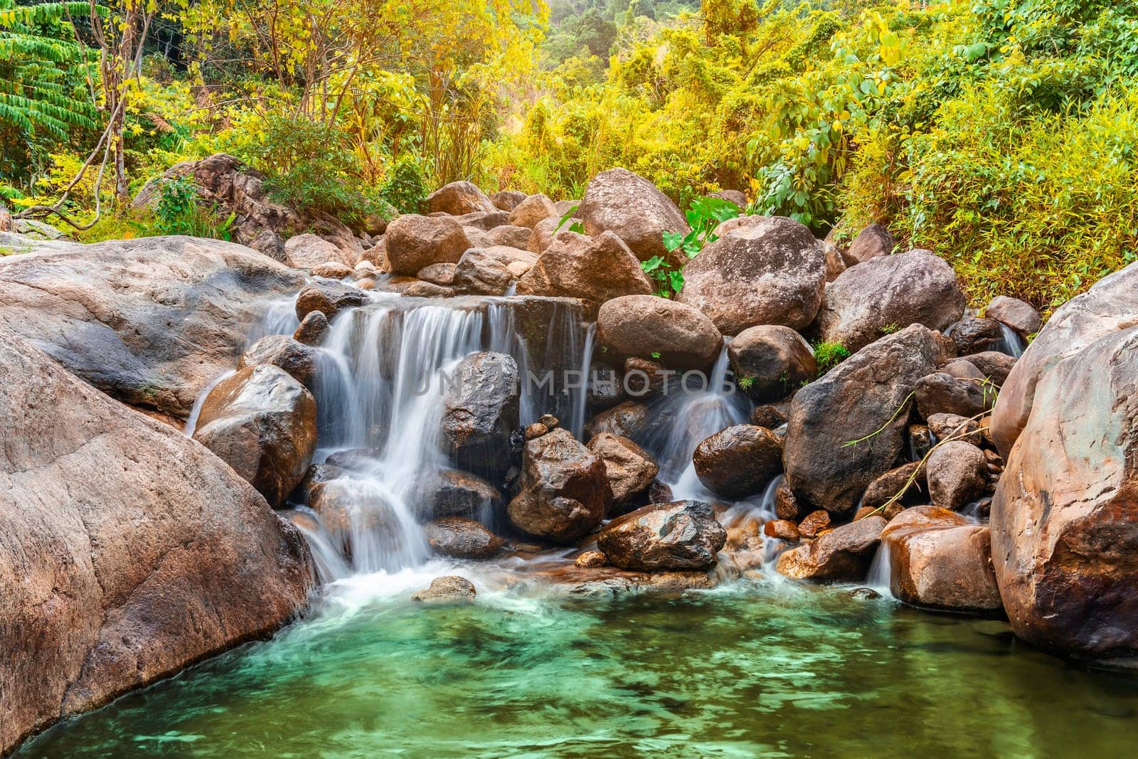 River stone and waterfall with tree colorful, View water river in countryside, Stone river in multi color tree leaf in forest