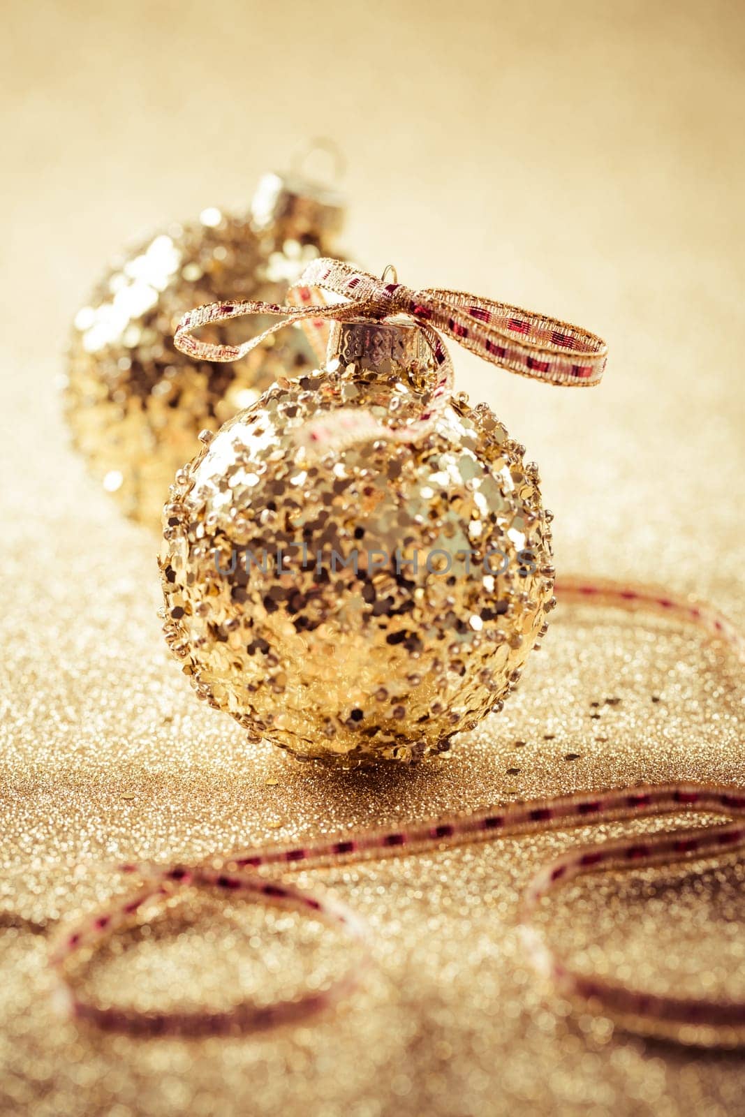 Golden christmas balls on glitter background with copy space. Glitter background.