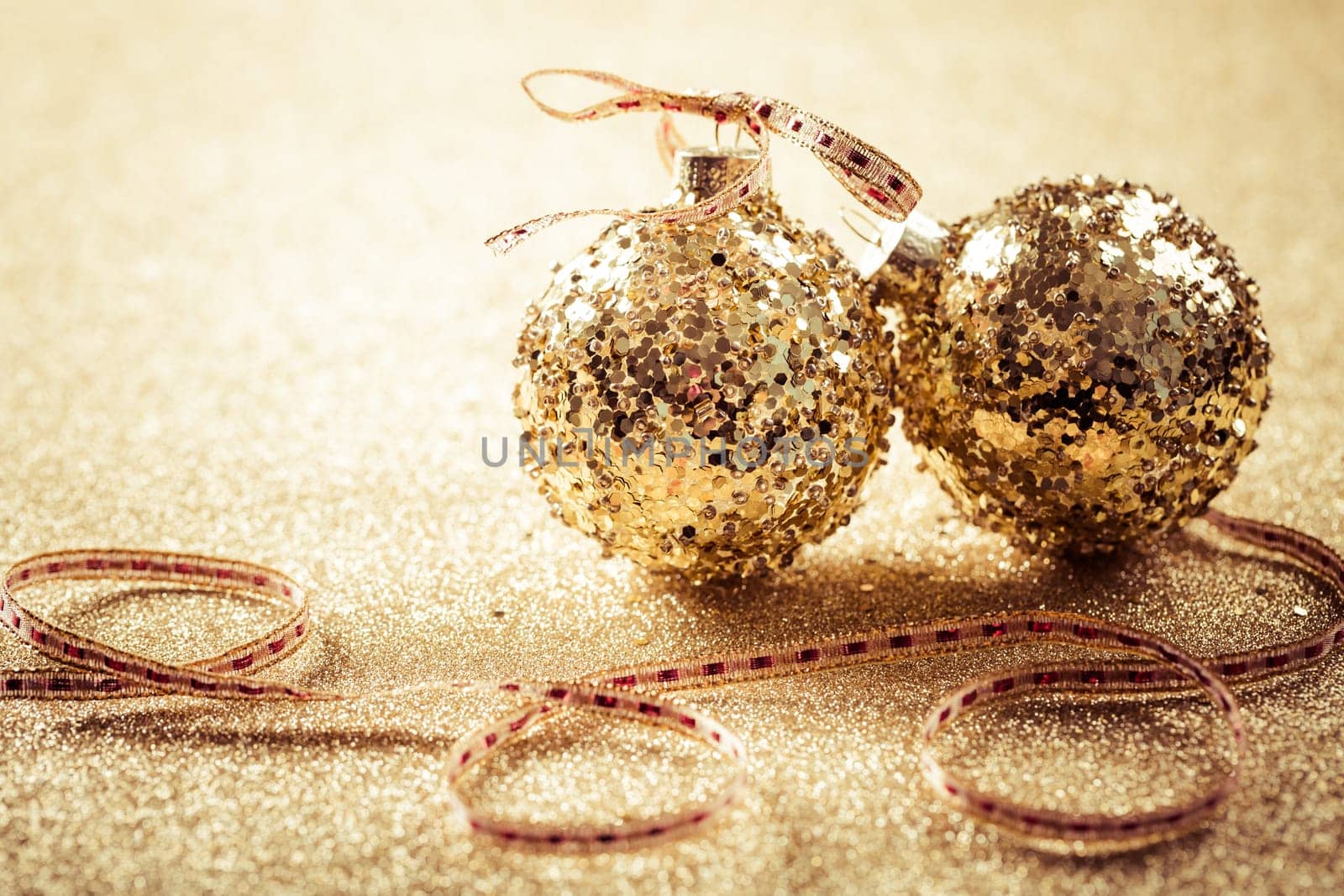 Golden christmas balls on glitter background with copy space. Glitter background.