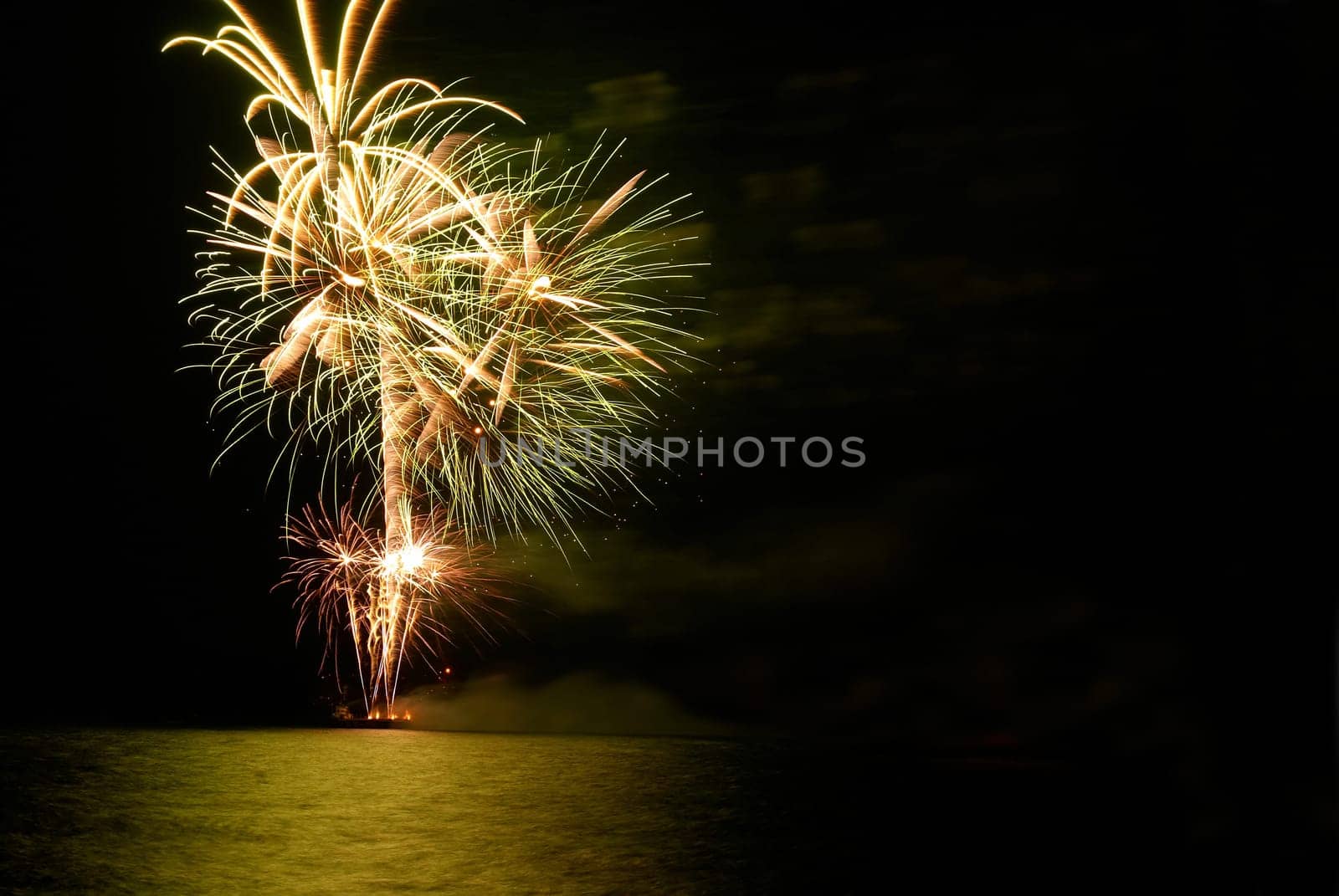 Yellow colorful holiday fireworks on the black sky background.