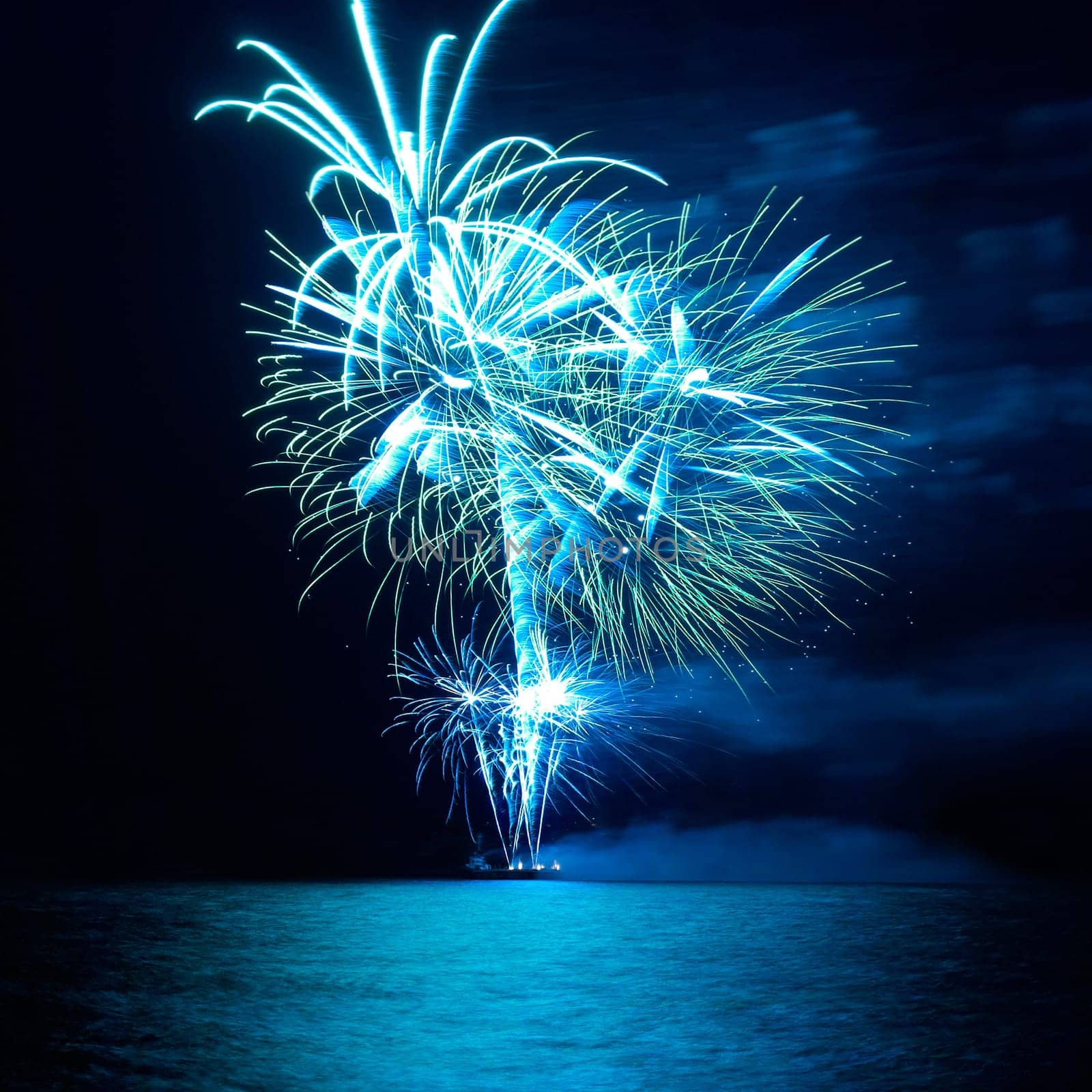 Blue colorful holiday fireworks on the black sky background.