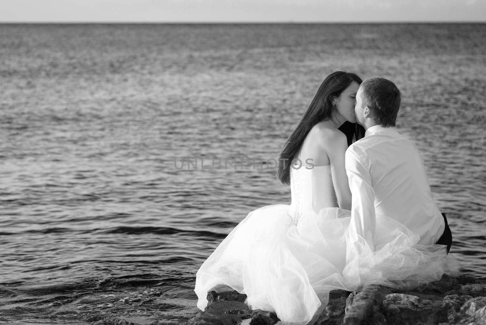Beautiful wedding couple - bride and groom hugging at the beach. Just married. Black and white, sepia