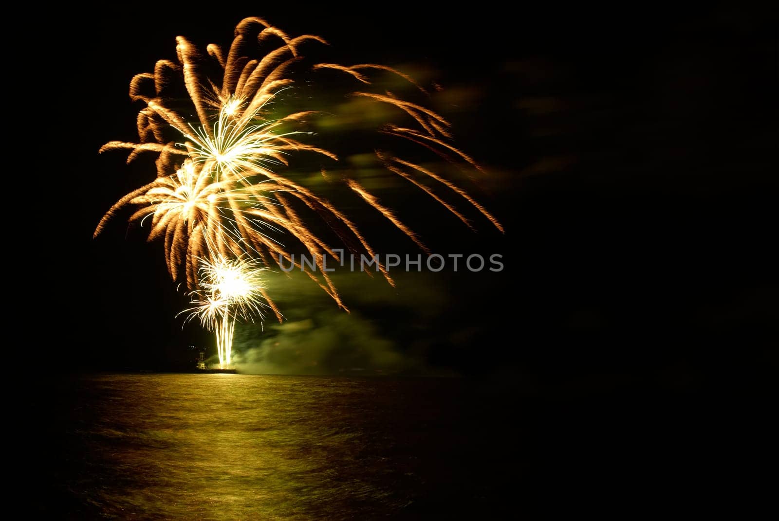Yellow colorful holiday fireworks on the black sky background.