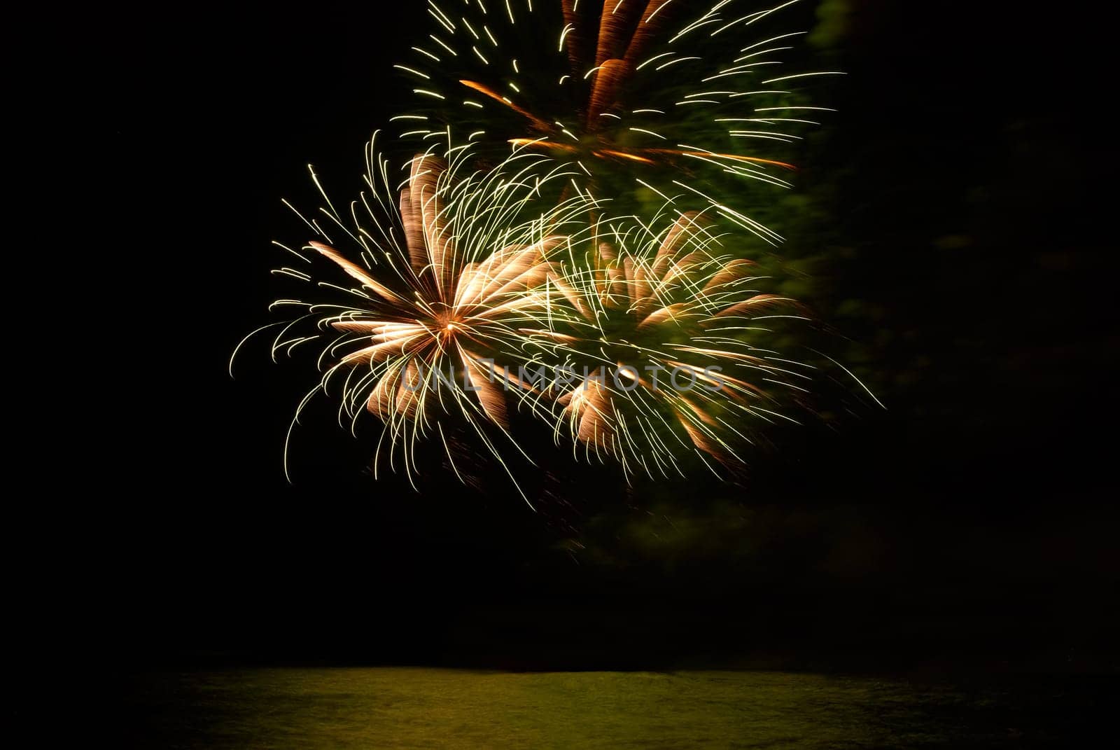 Yellow colorful holiday fireworks on the black sky background.