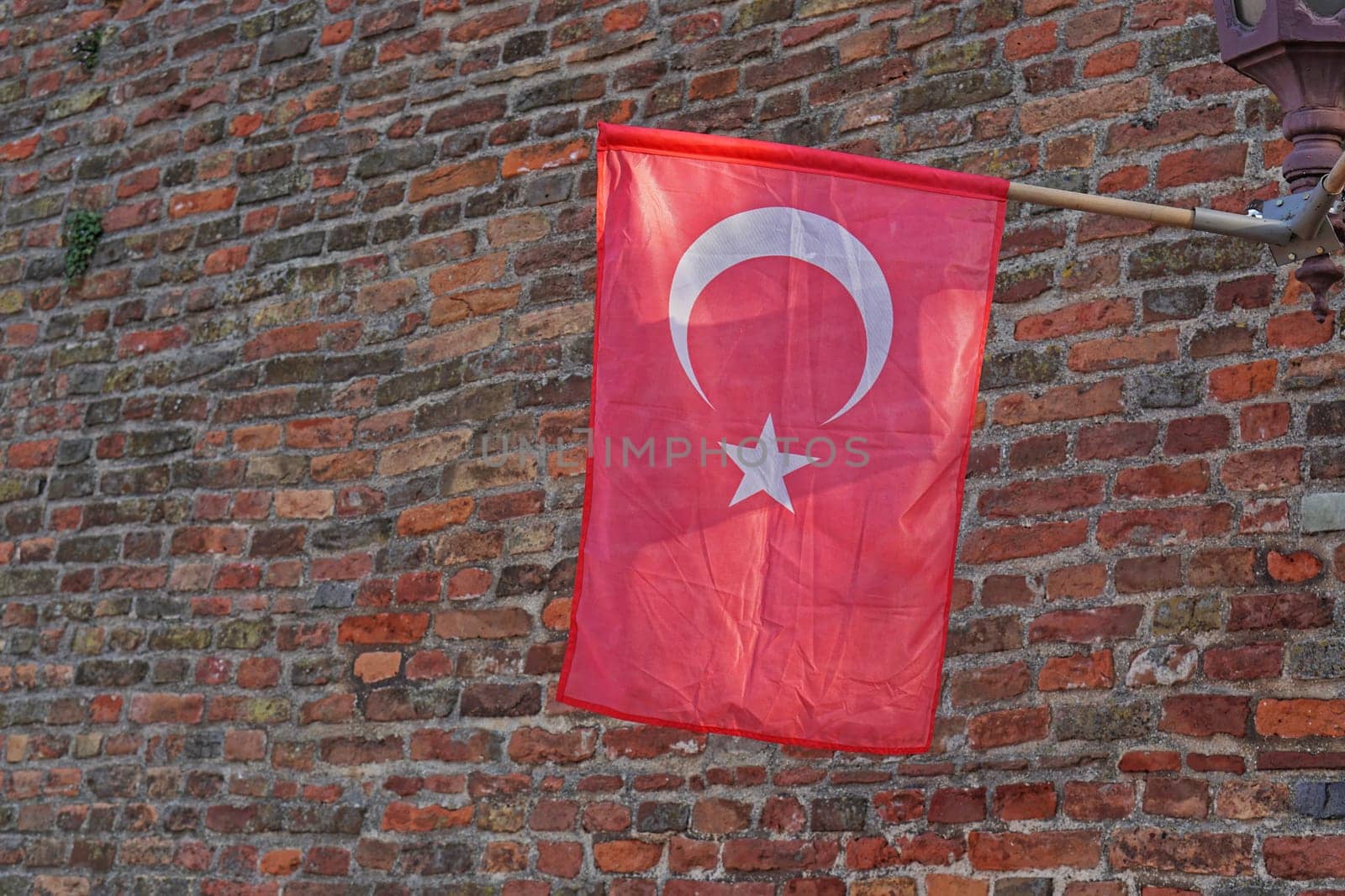 Official Turkey flag with star and crescent at brick wall