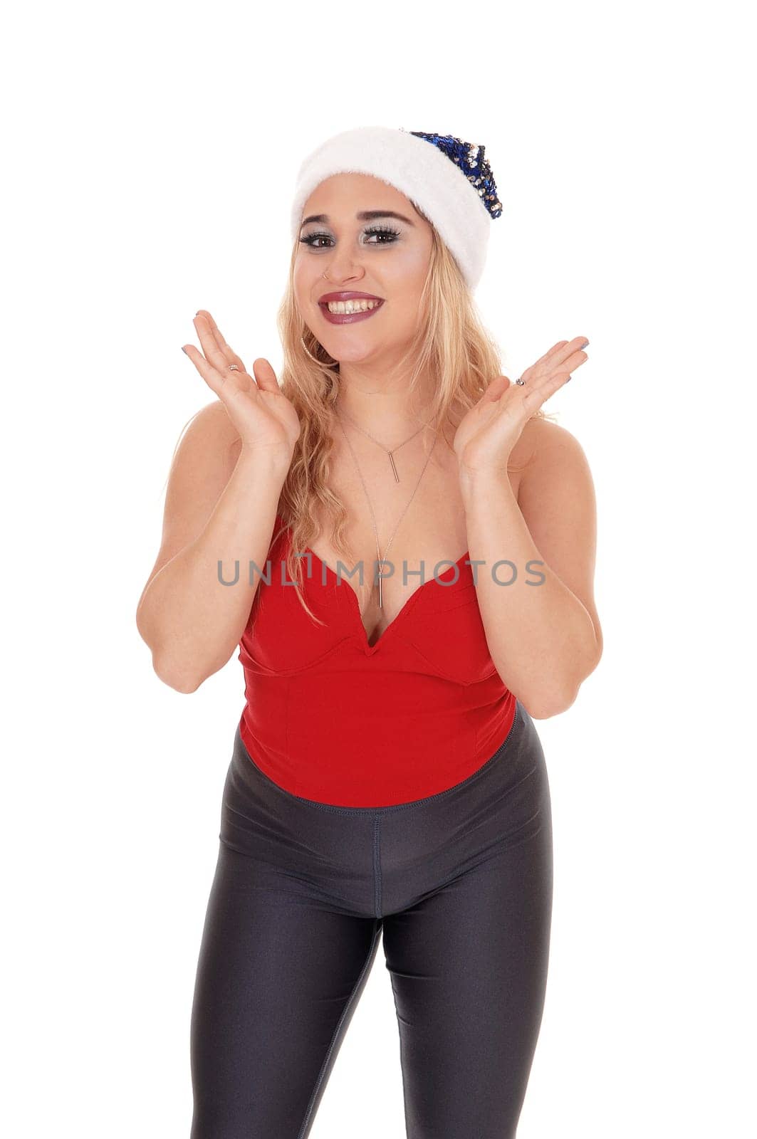 beautiful young blond woman standing in a red top, gray tights and a.blue Santa hat, isolated for white background.