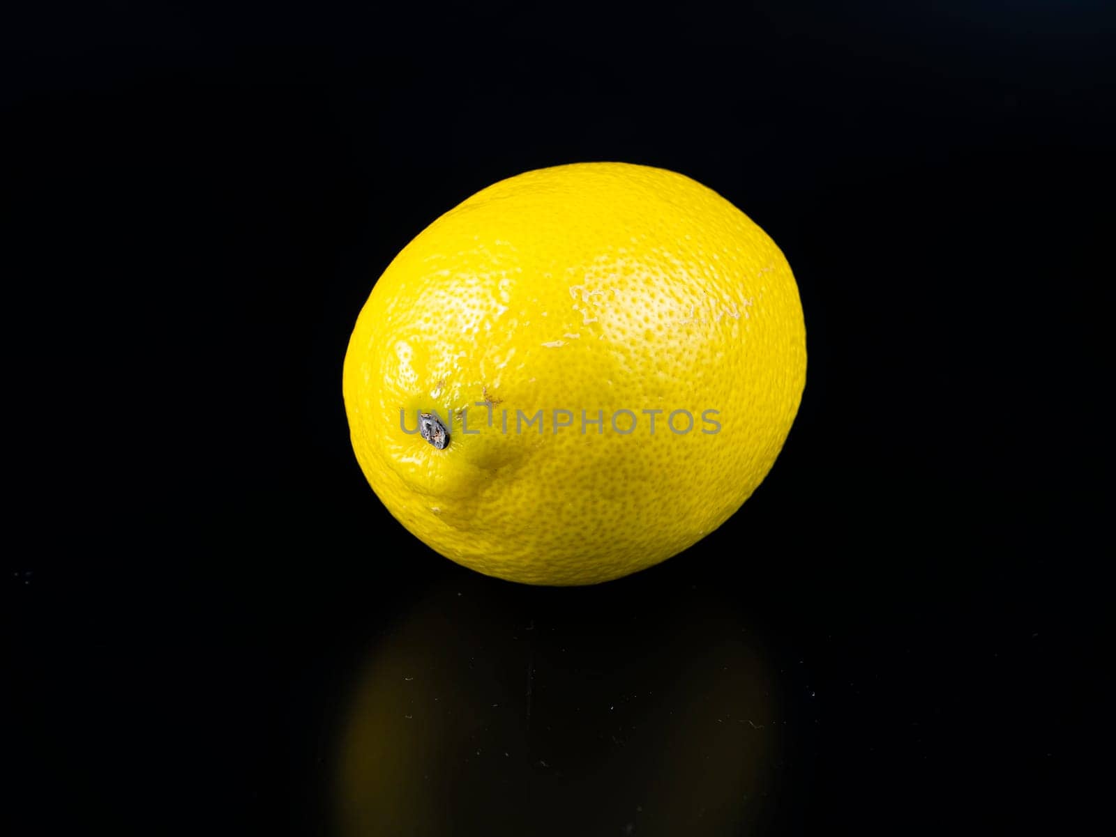 Yellow lemon fruit on a black background with place for text. Harvest. Food photo.